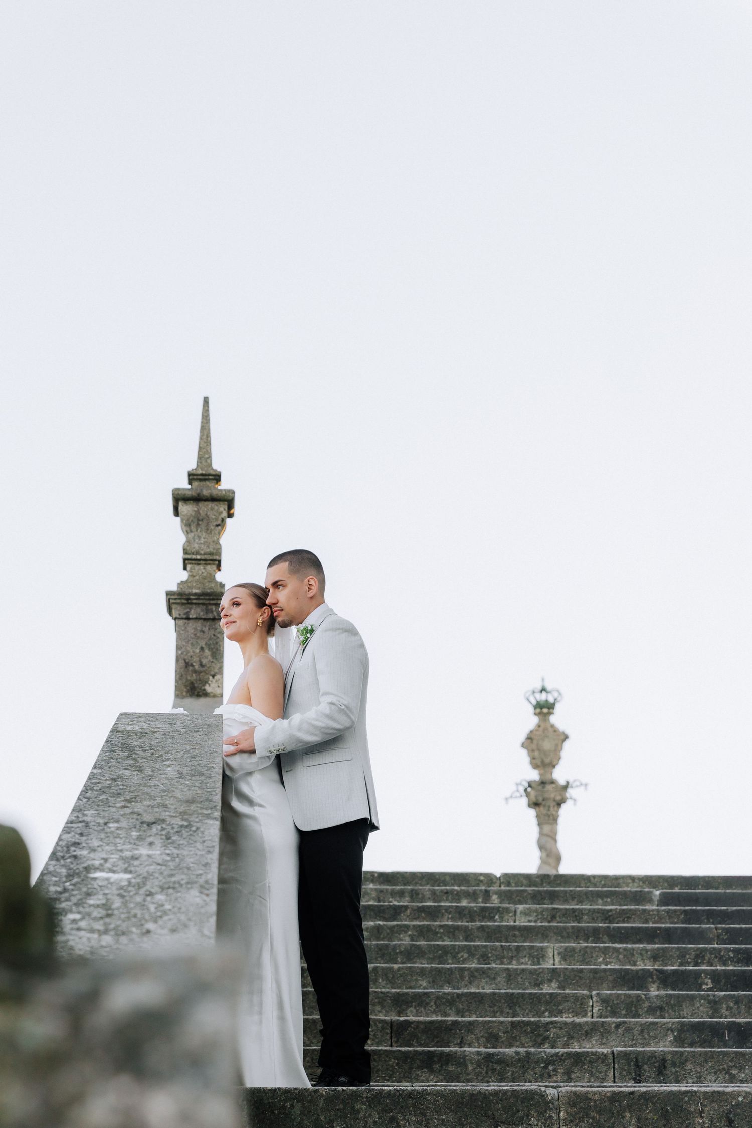 Romantic embrace under Porto's iconic Dom Luis bridge on a misty day.