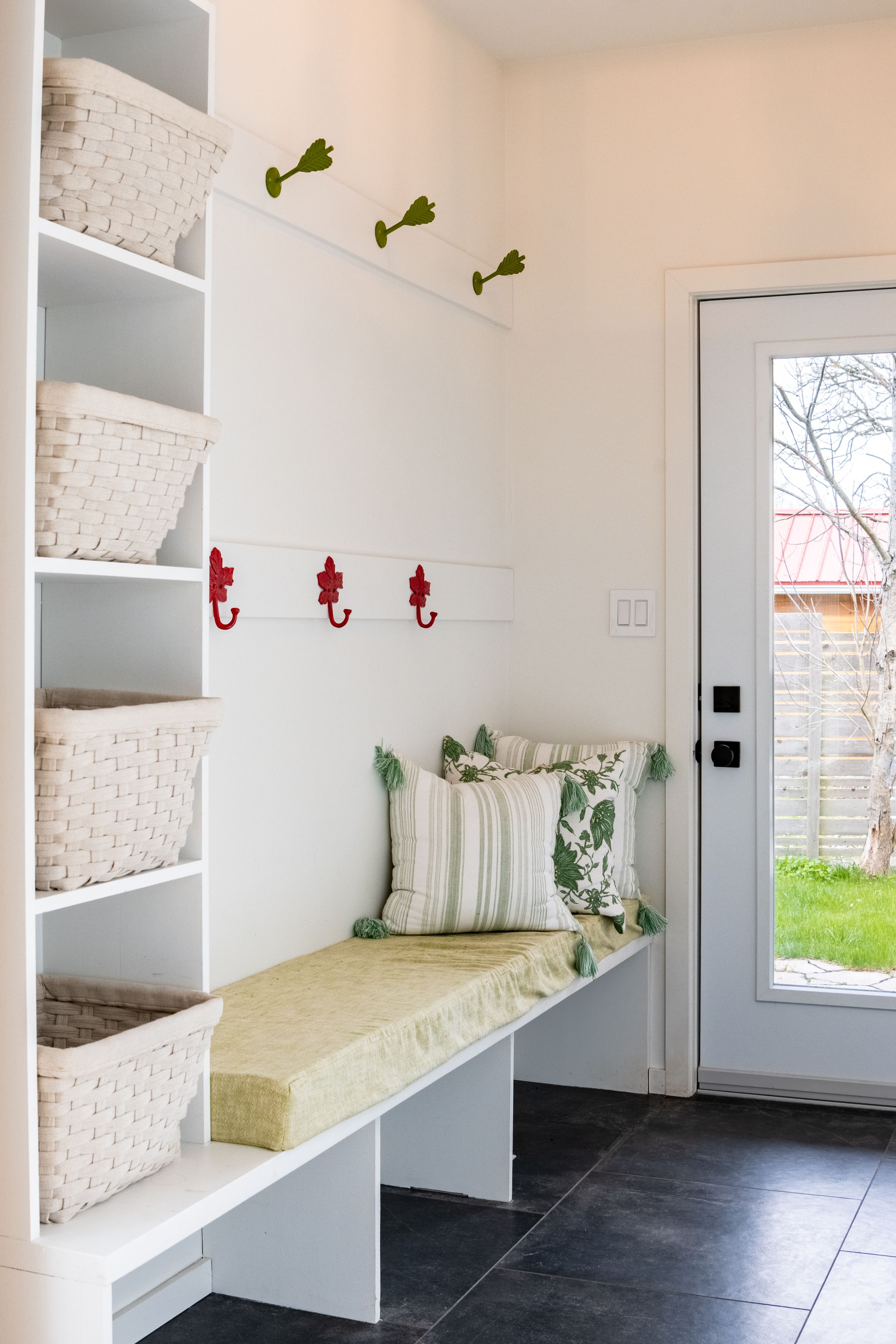 Clean mudroom with built-in storage benches and white brick accents.