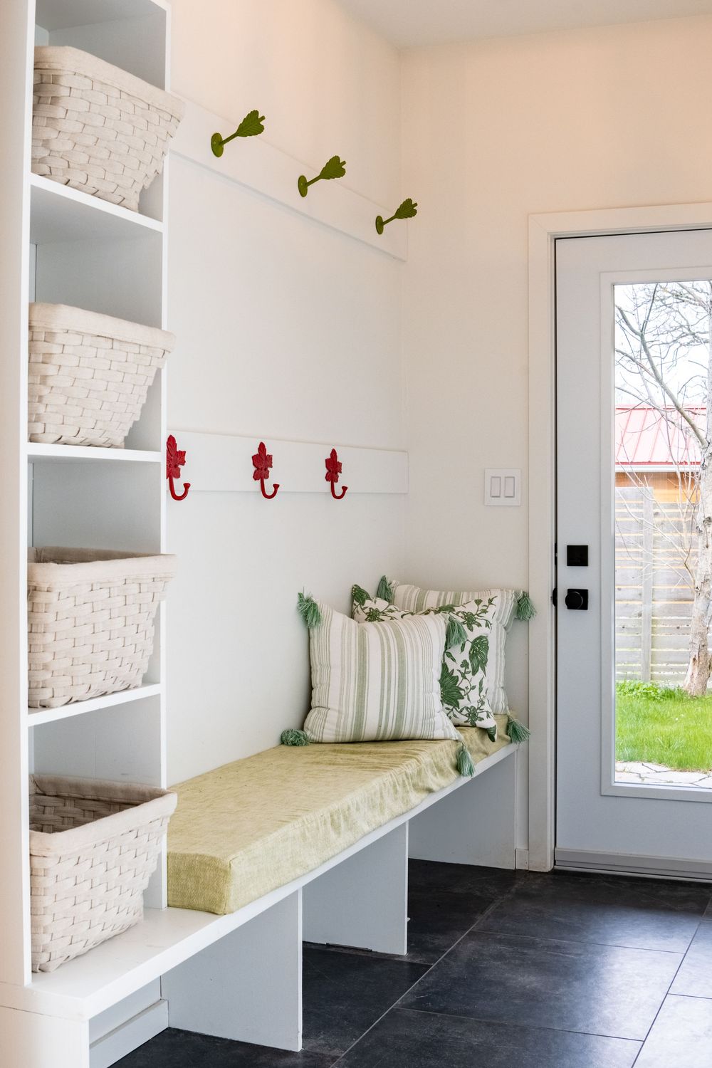 Clean mudroom with built-in storage benches and white brick accents.