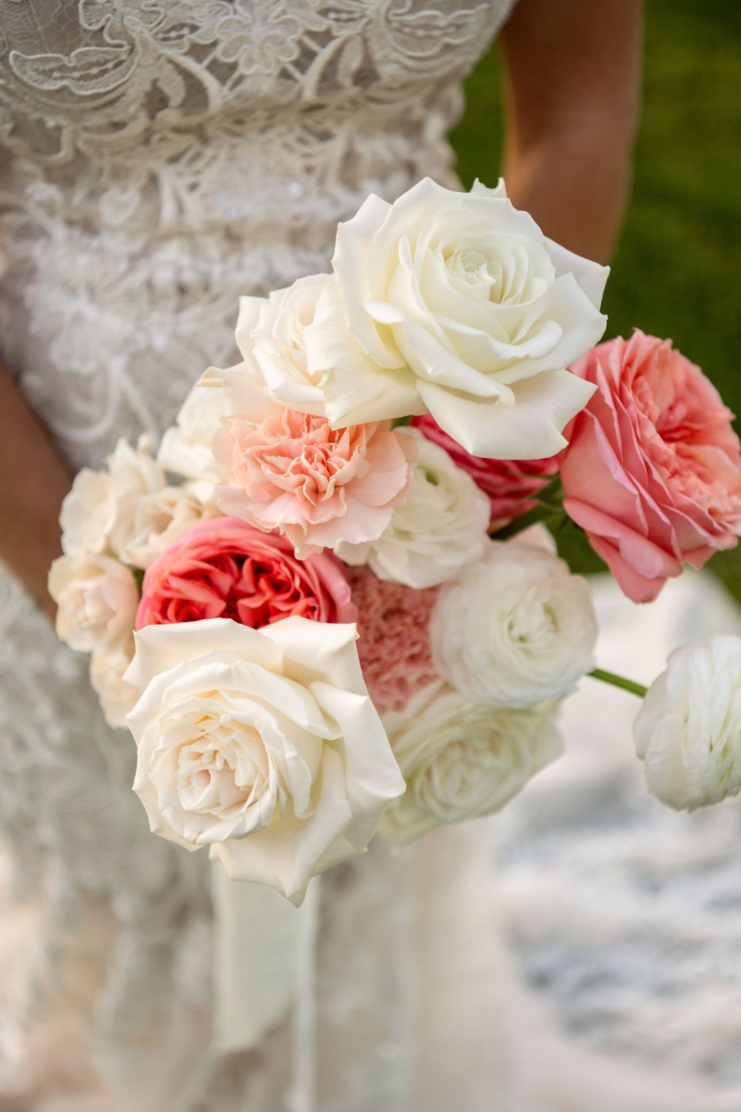 Delicate pink and white roses arranged in a romantic floral display with lace details.
