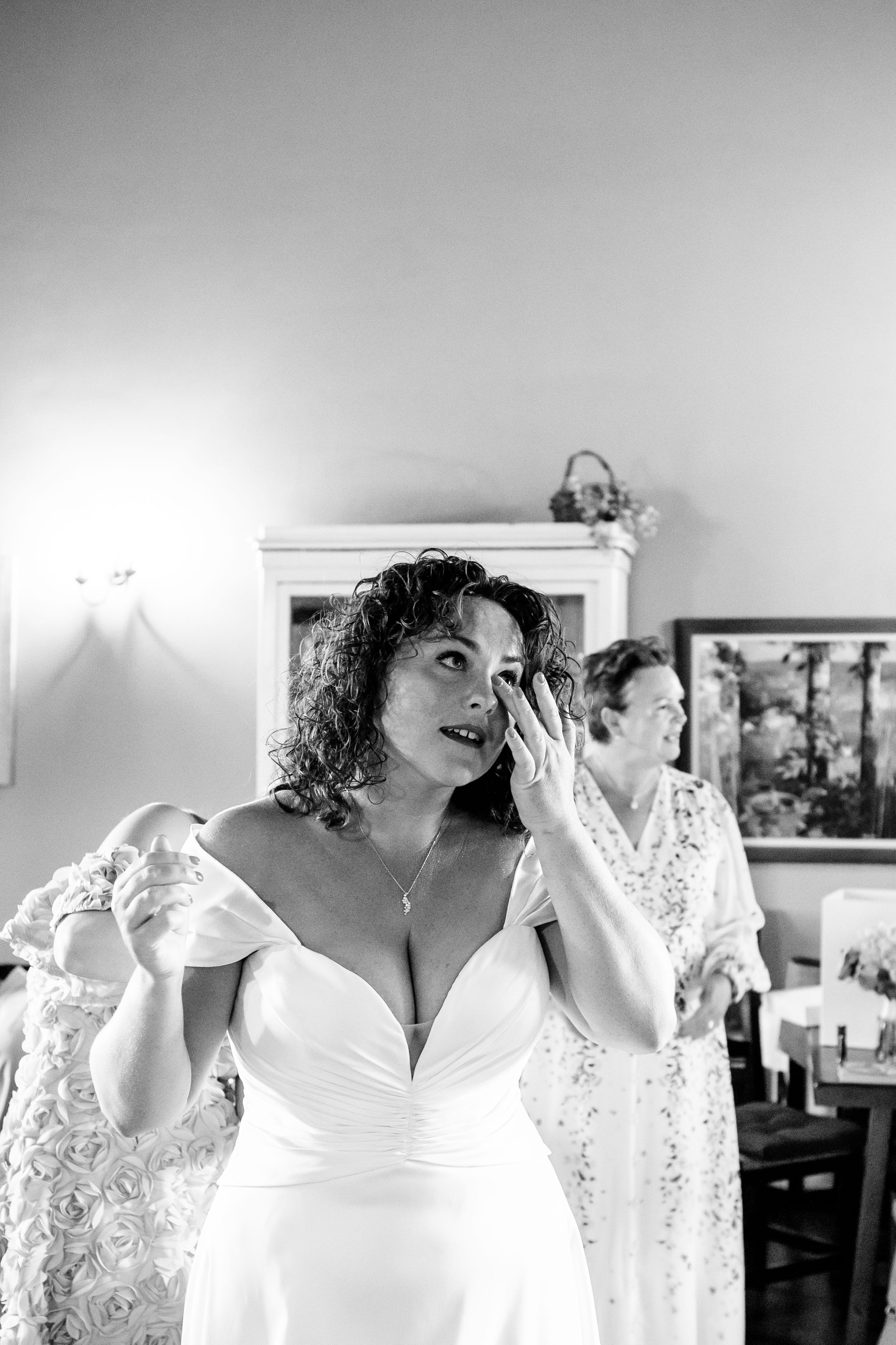 Black and white photograph showing a moment of getting ready in an interior room at a Tuscan wedding.