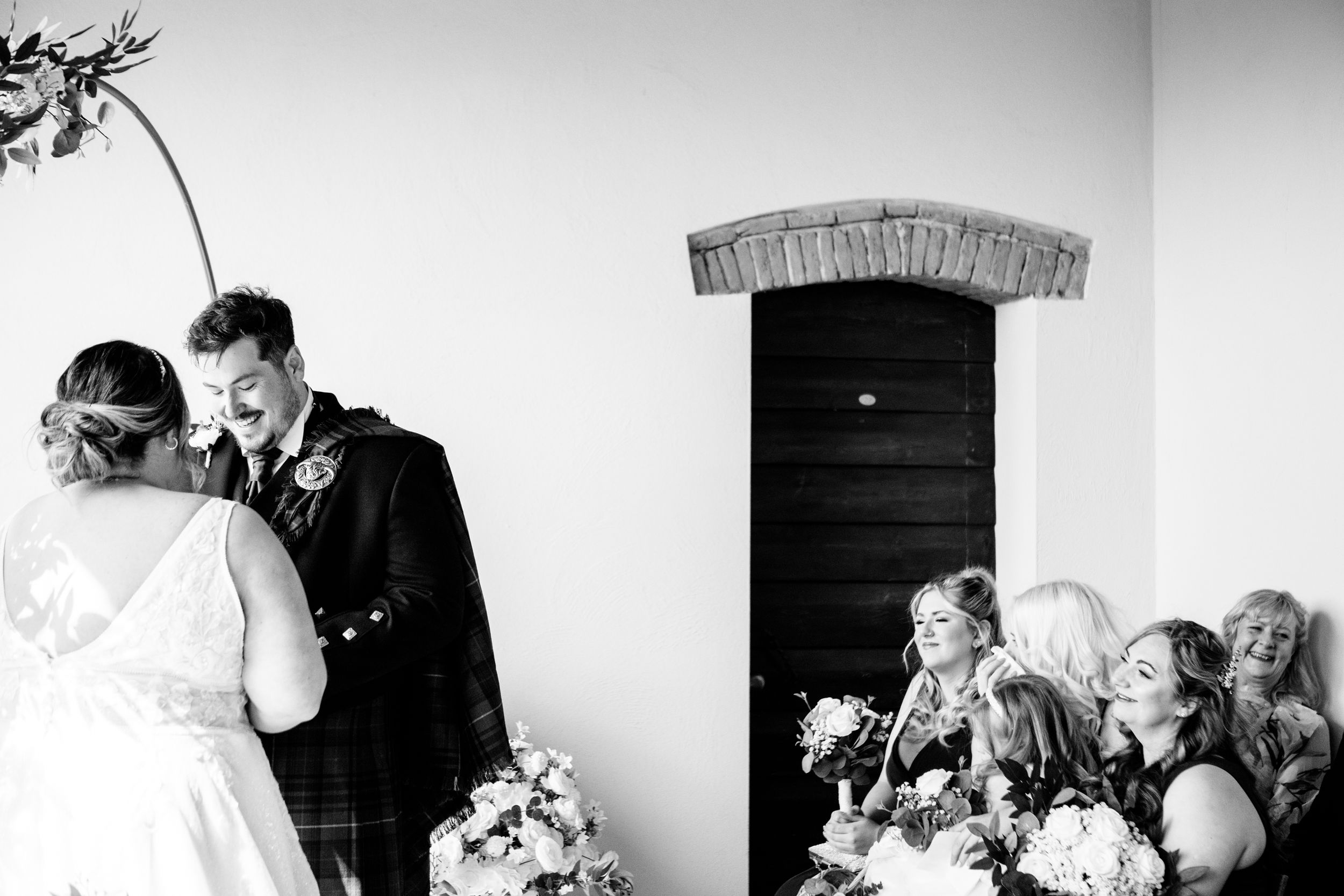A black and white wedding moment captured with laughter and joy during an outdoor celebration at Villa Petrea in Tuscany, Italy.