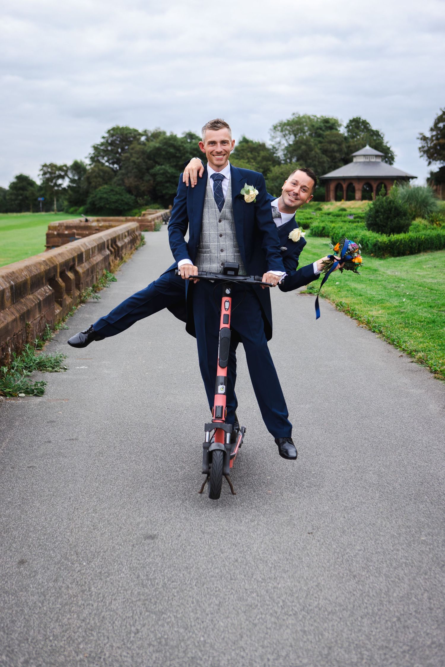 Fun sequence of suits riding small bicycle on park path.