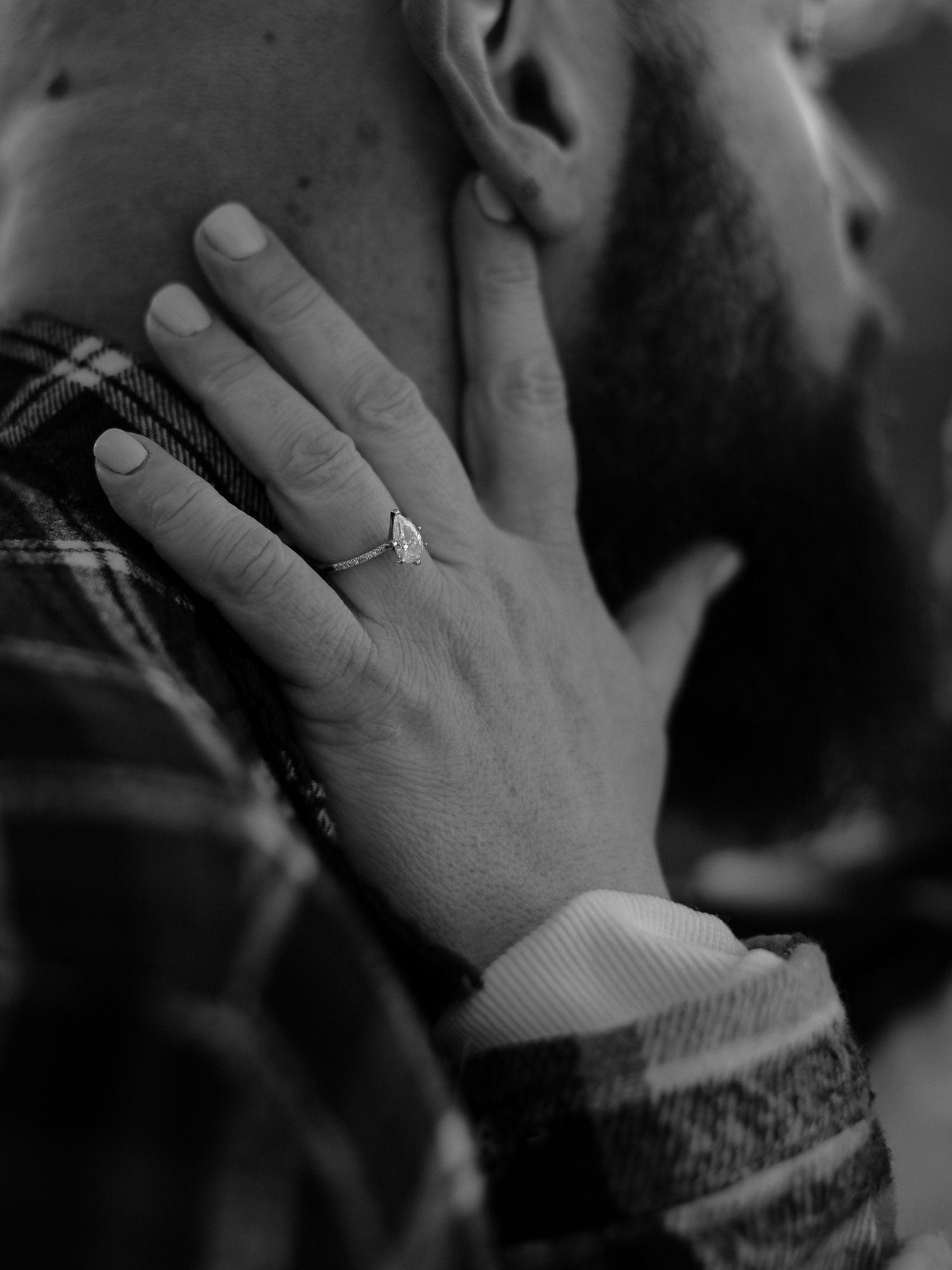 An intimate black and white portrait of a couple sharing a romantic moment.