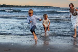 A playful beach scene during golden hour with splashing in the ocean waves at sunset.