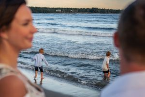 People enjoying a serene evening at the beach with gentle waves rolling in.