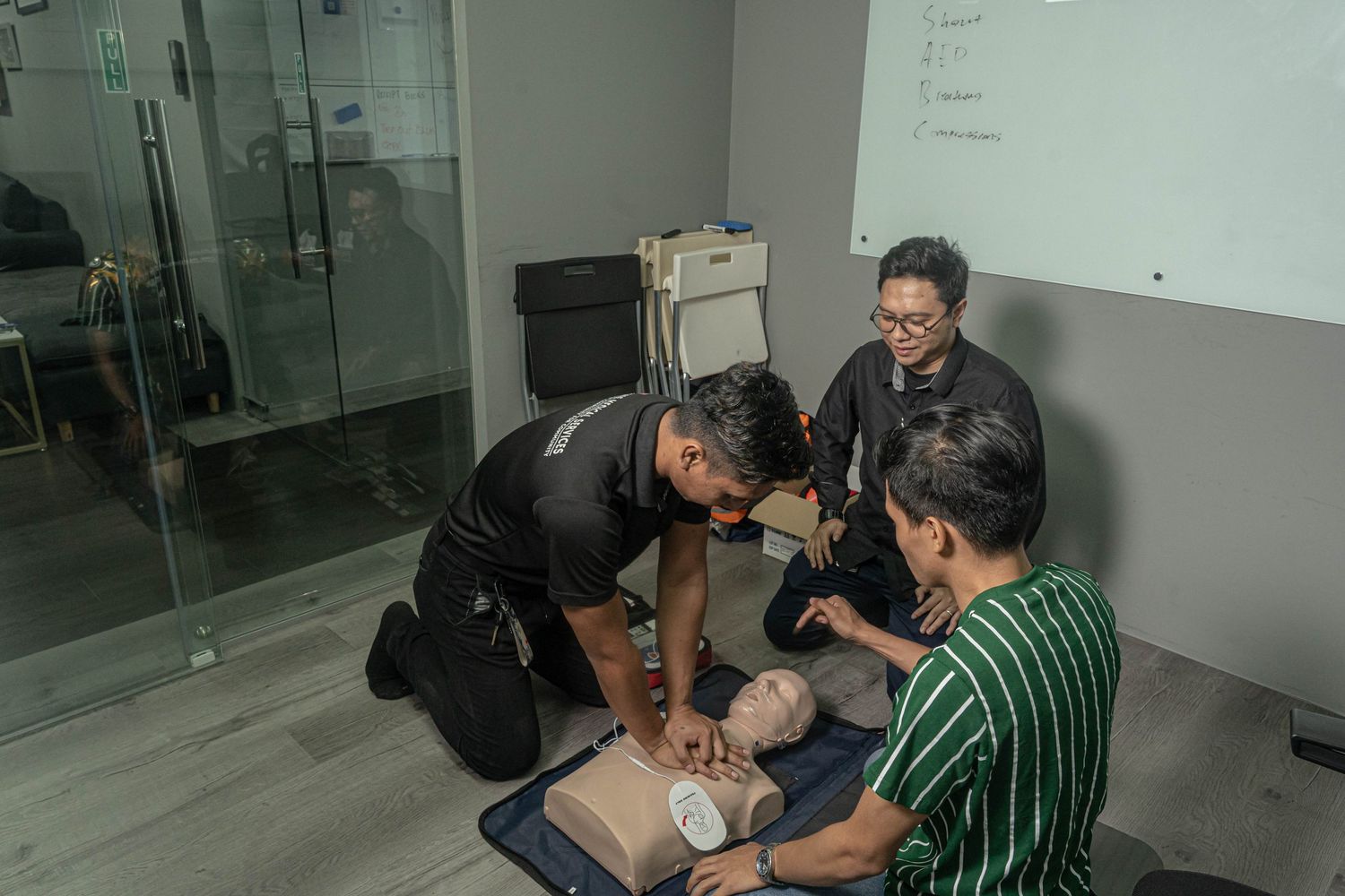 Medical professionals practicing CPR on training dummy during emergency response training.