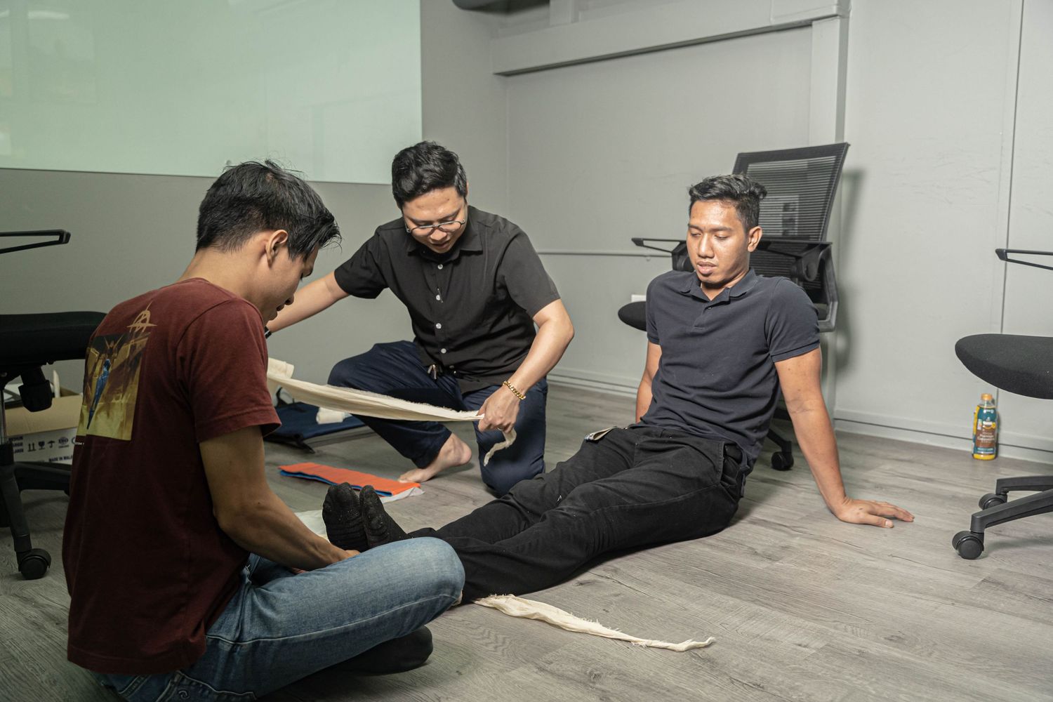 Medical training session showing professionals practicing leg splinting techniques.