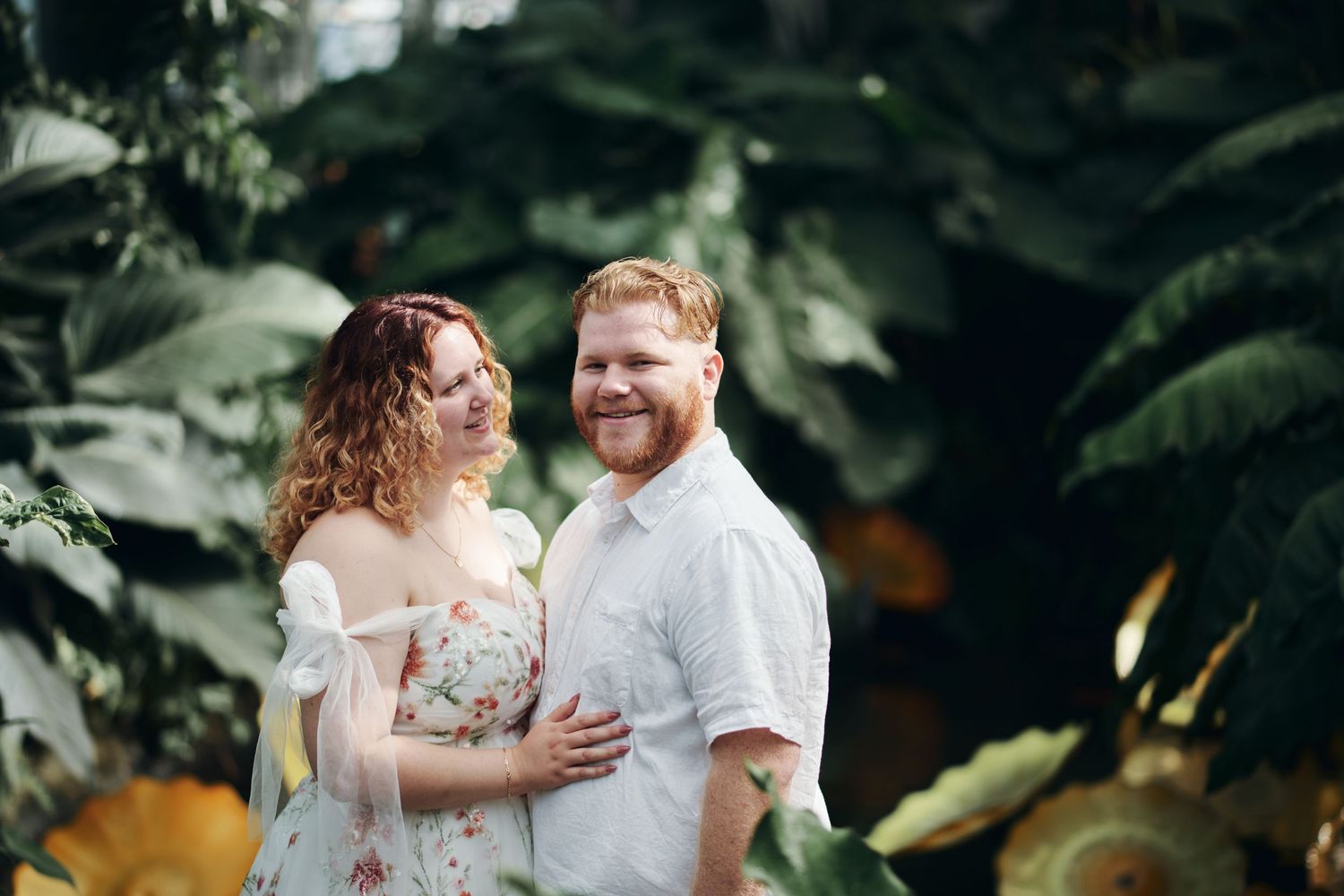 A couple shares romantic moments in a lush garden setting during a wedding photo session.
