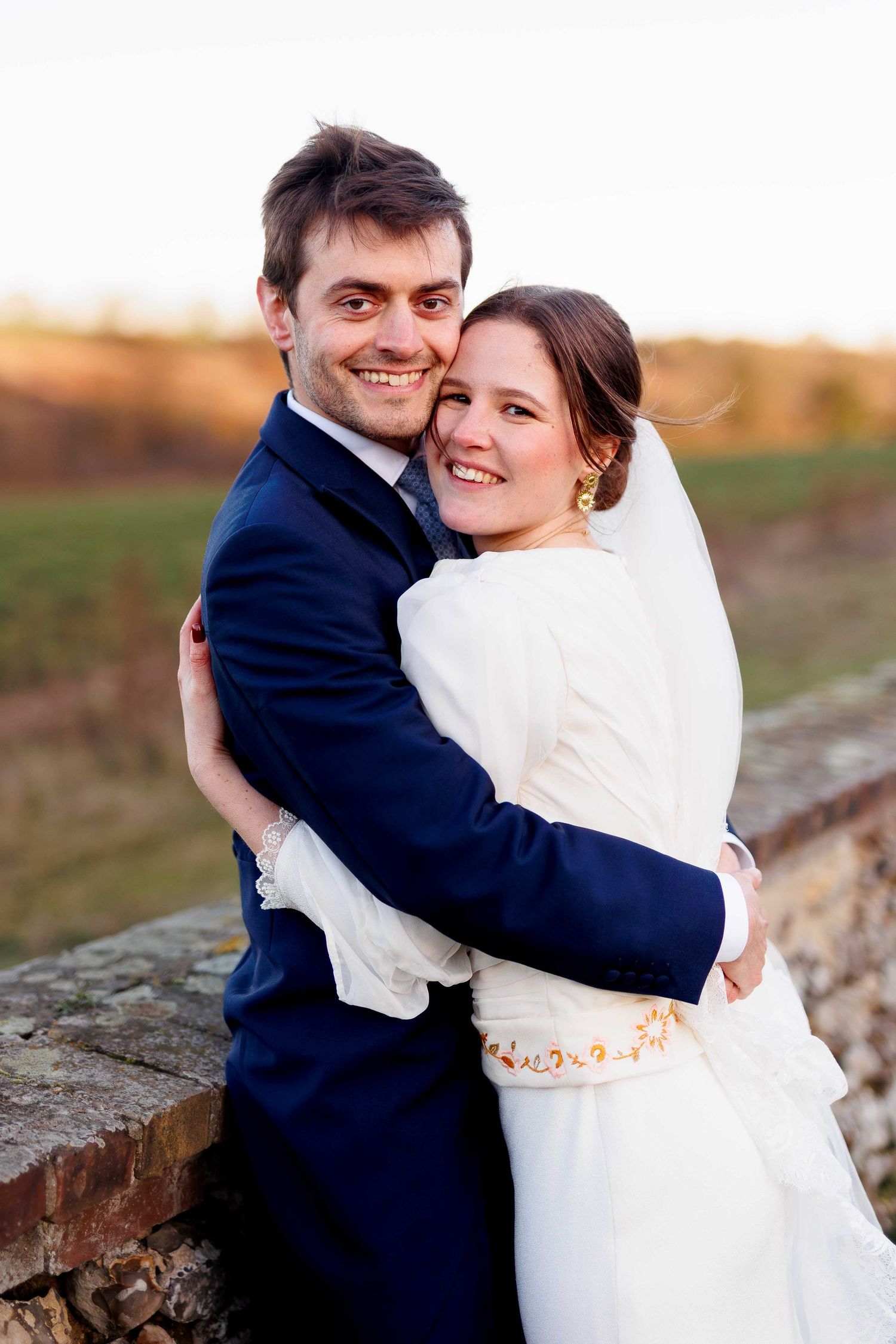 Photos de mariage romantiques montrant un couple s'enlaçant au coucher du soleil, à la Grange de Bourgoult en Normandie proche de Rouen