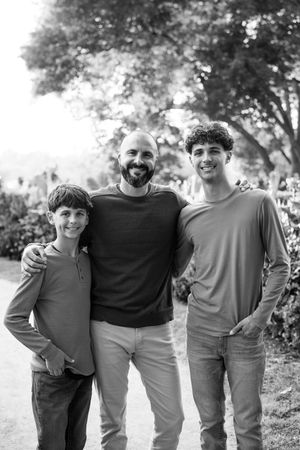 A group of people wearing casual sweaters and pants pose together outdoors in a black and white photograph.
