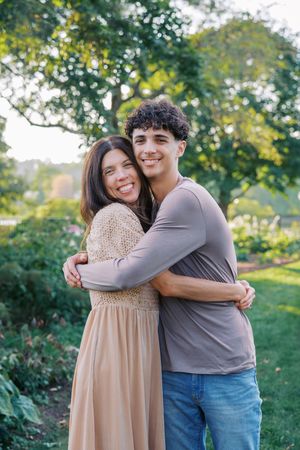 A loving embrace captured in a garden setting with yellow flowers and lush greenery.