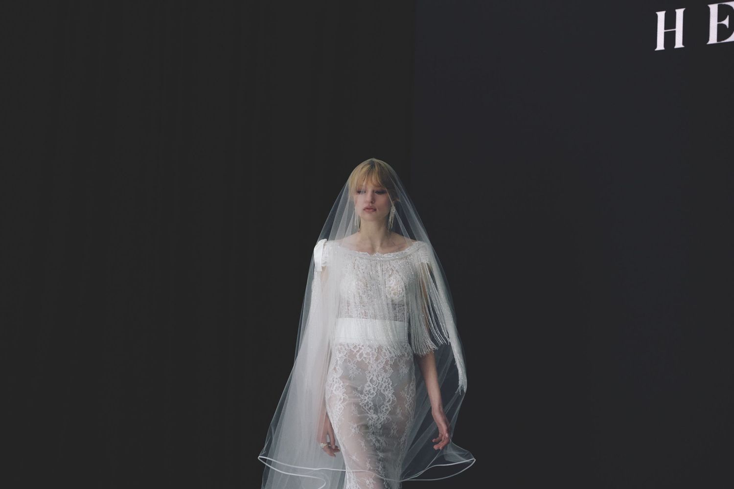 Ethereal bridal collection featuring flowing white veils and delicate details against dark backdrop.