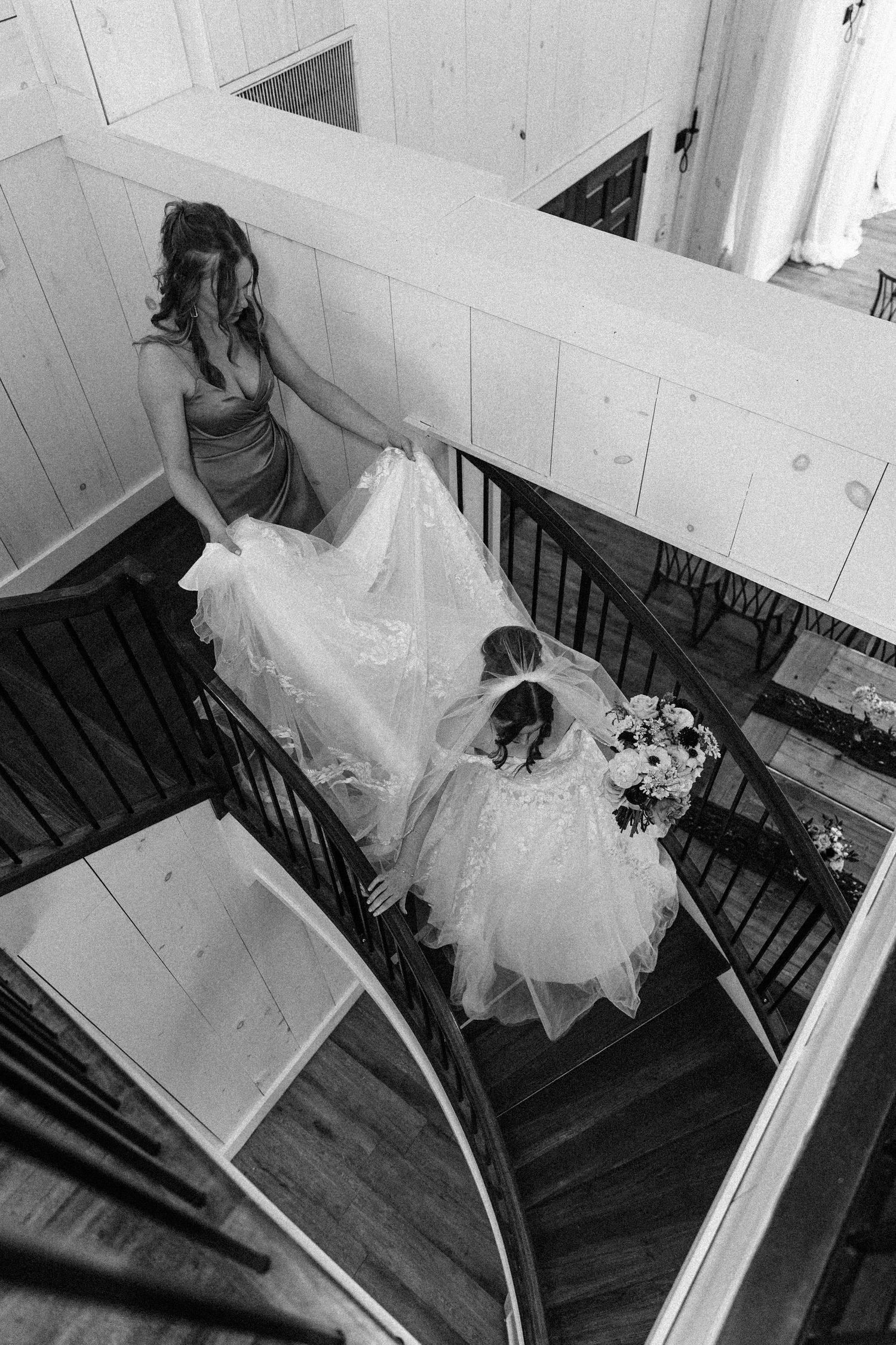 A series of black and white photos showing a bride in a flowing wedding dress descending a staircase.