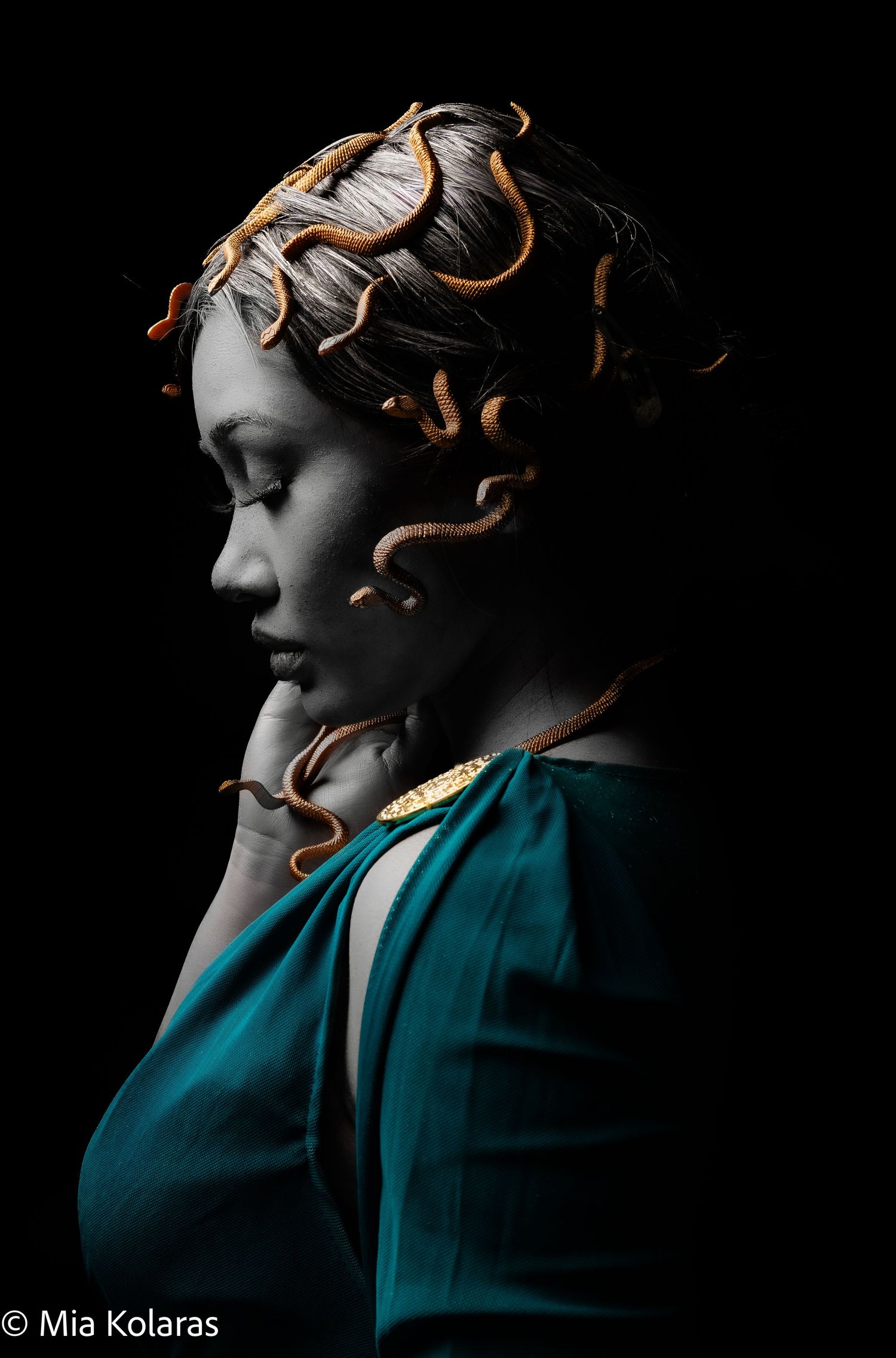 Medusa, girl fully painted in grey paint with golden snakes, looking down with eyes closed