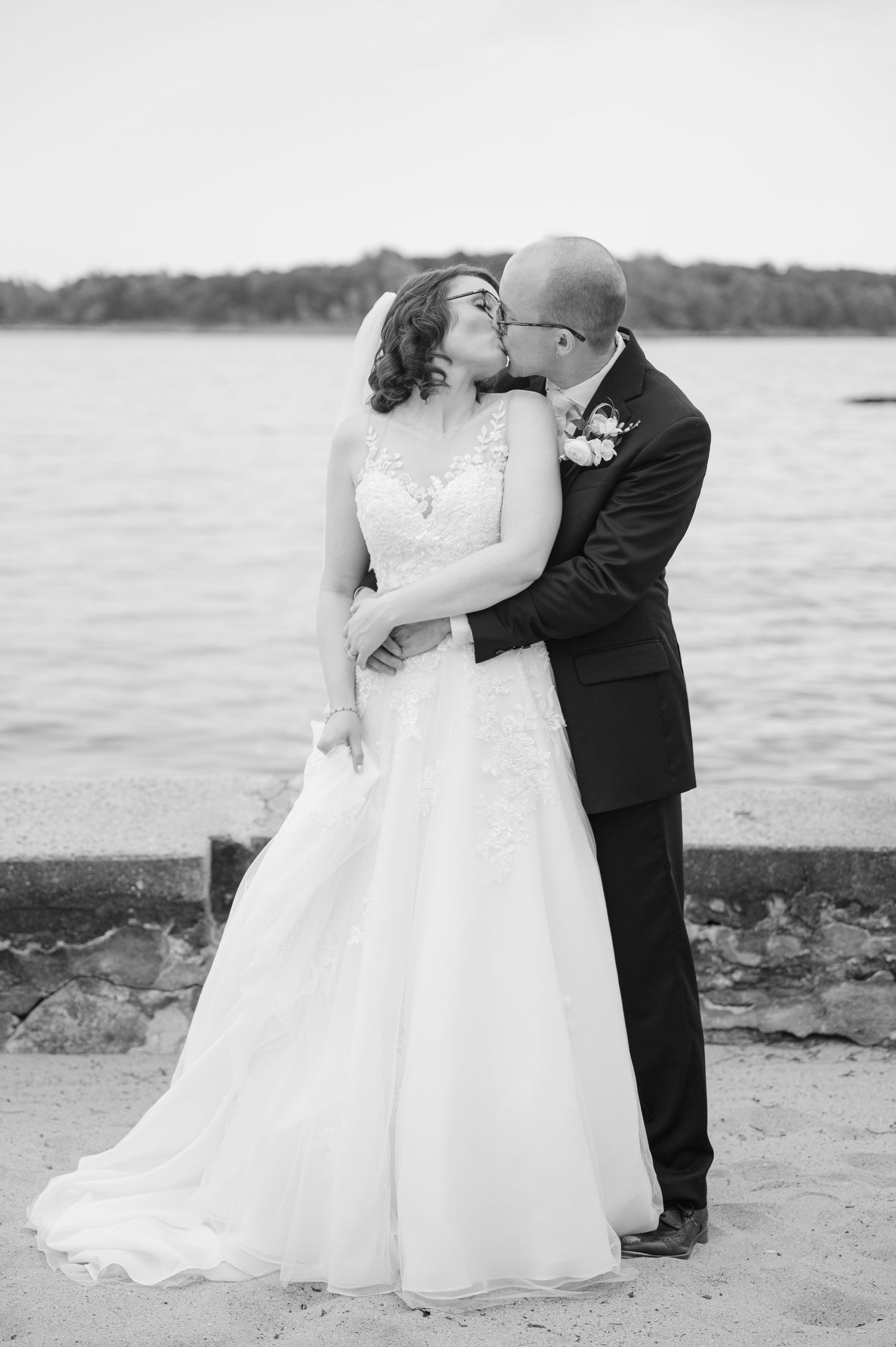 Bride and groom dancing by the waterfront, bride in flowing white gown, groom in black tuxedo at the Davenport Mansion in New Rochelle, NY.