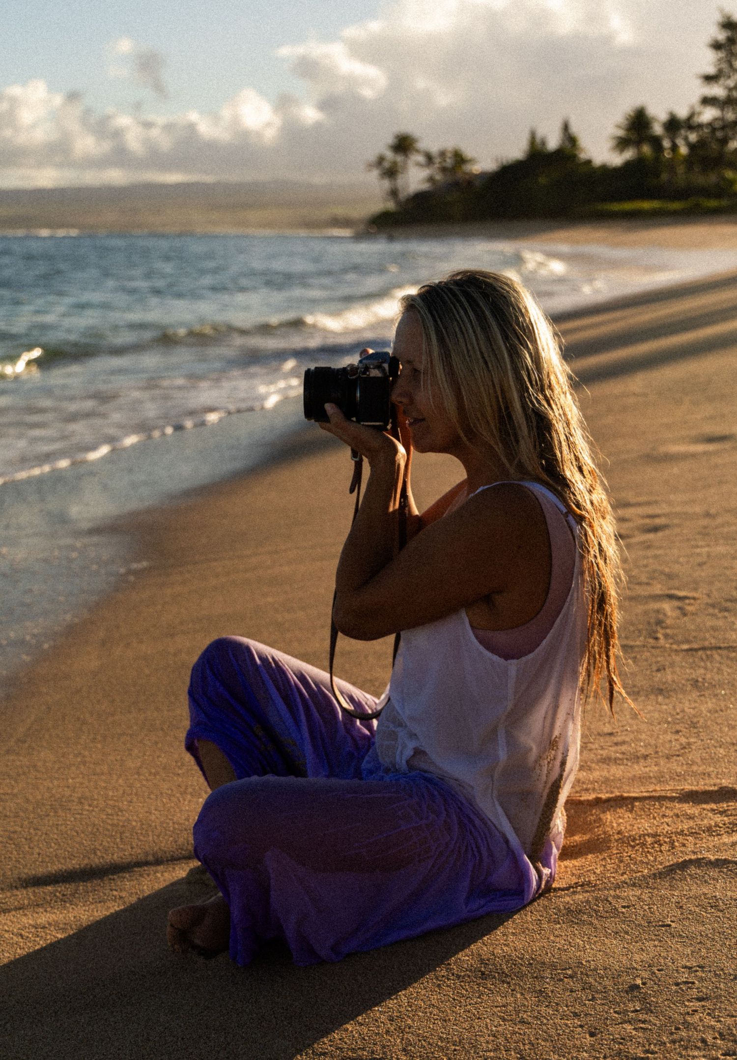 Photographer creating images on a sandy North Shore Oahu beach at sunset.