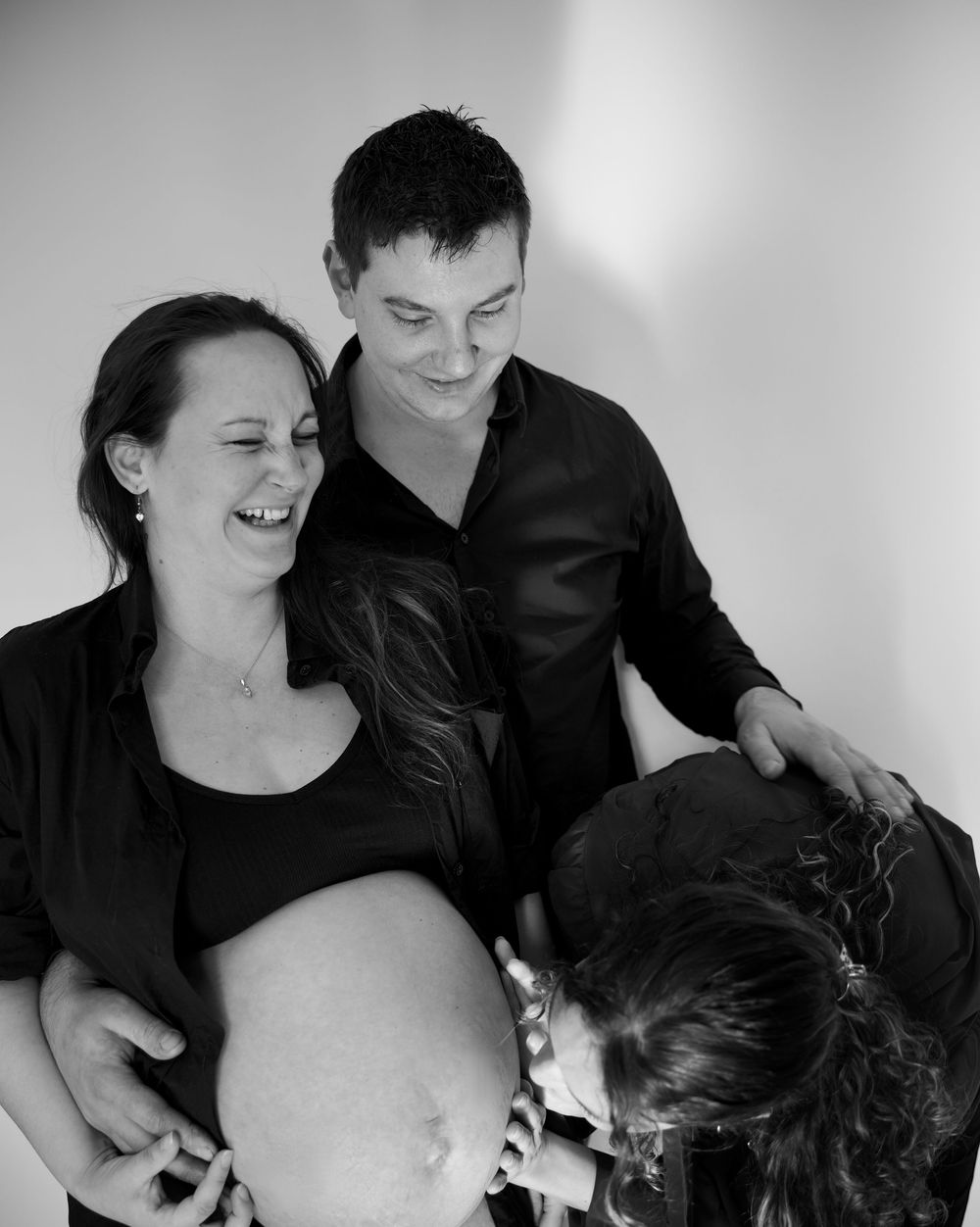 Famille en séance maternité dans les Bouches-du-Rhône, photo noir et blanc naturelle et complice autour du bébé à venir.