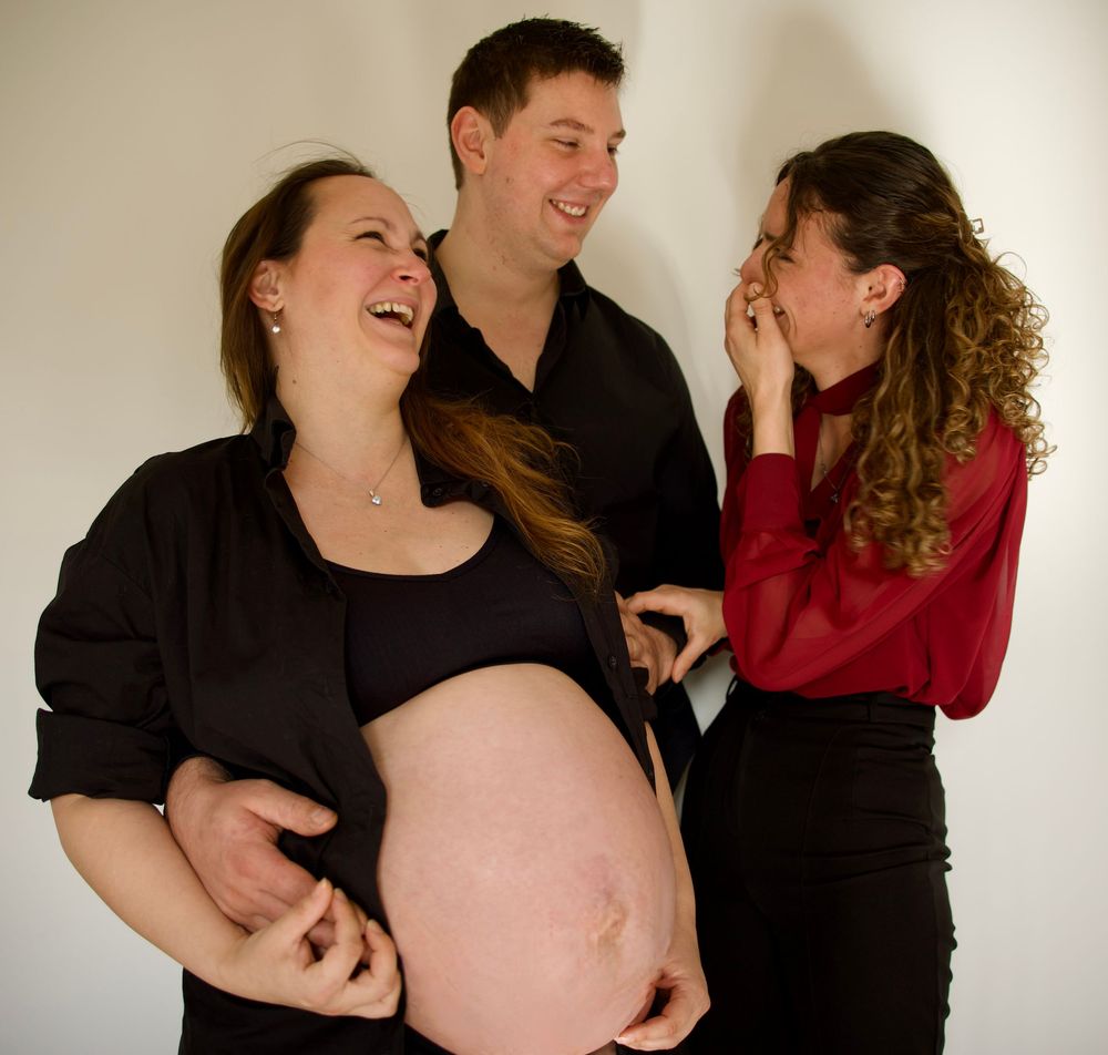 Famille et marraine en séance grossesse à Aix-en-Provence, moment joyeux et complice autour du ventre rond.