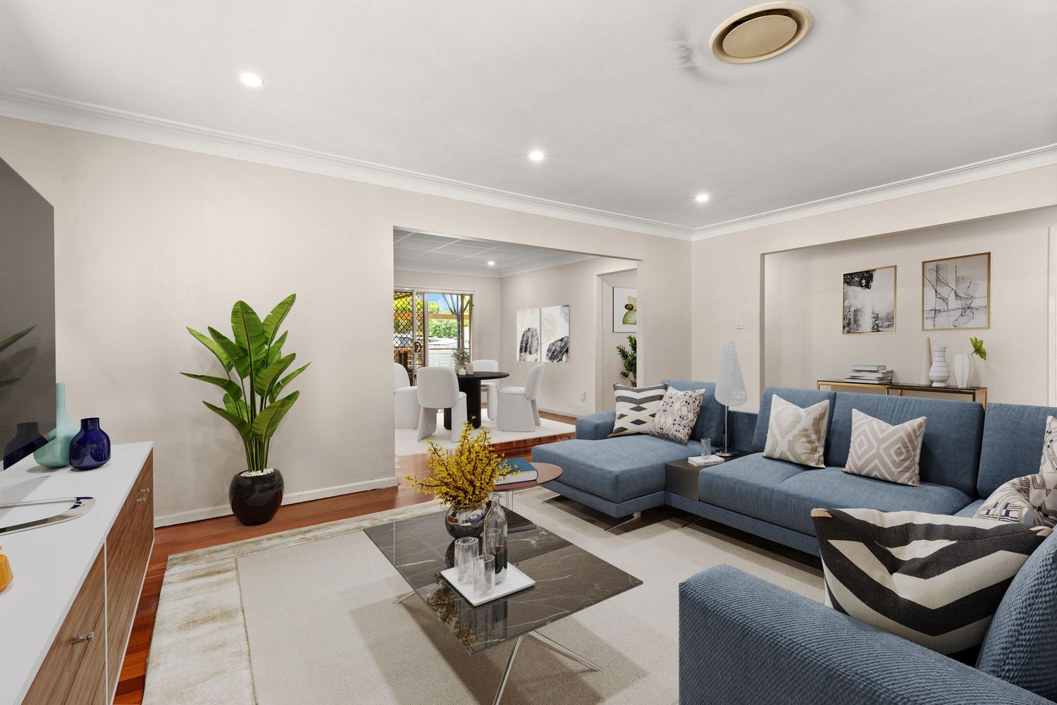 Modern living room featuring blue sectional sofa, marble coffee table, timber floors, and stylish neutral decor.