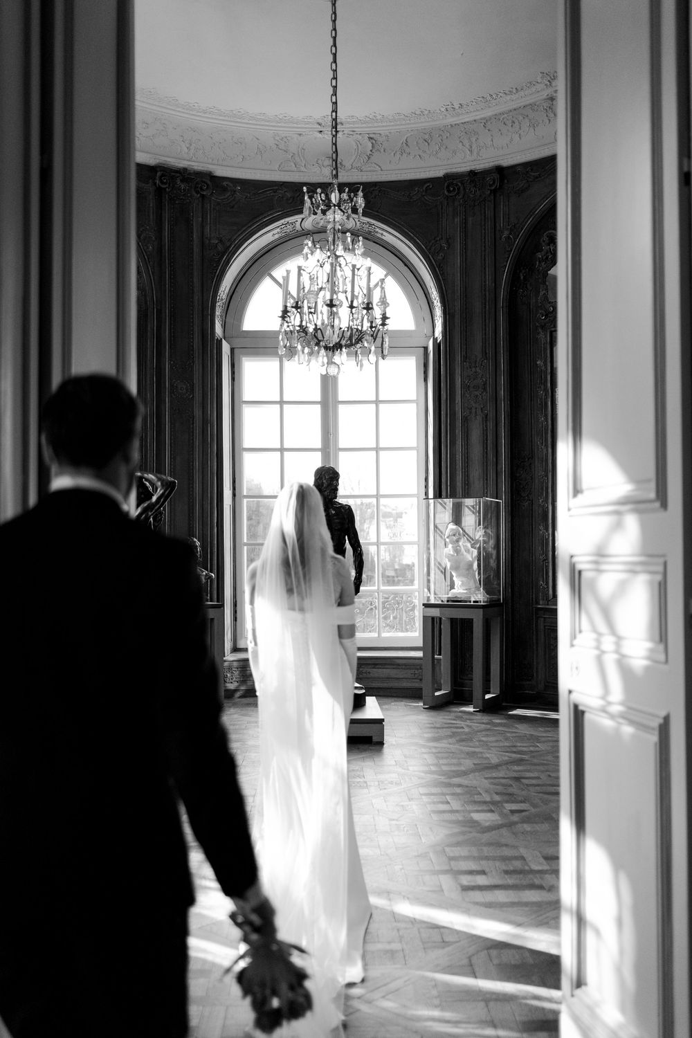 A series of black and white photos showing ghostly figures in elegant palace rooms with tall windows and chandeliers.