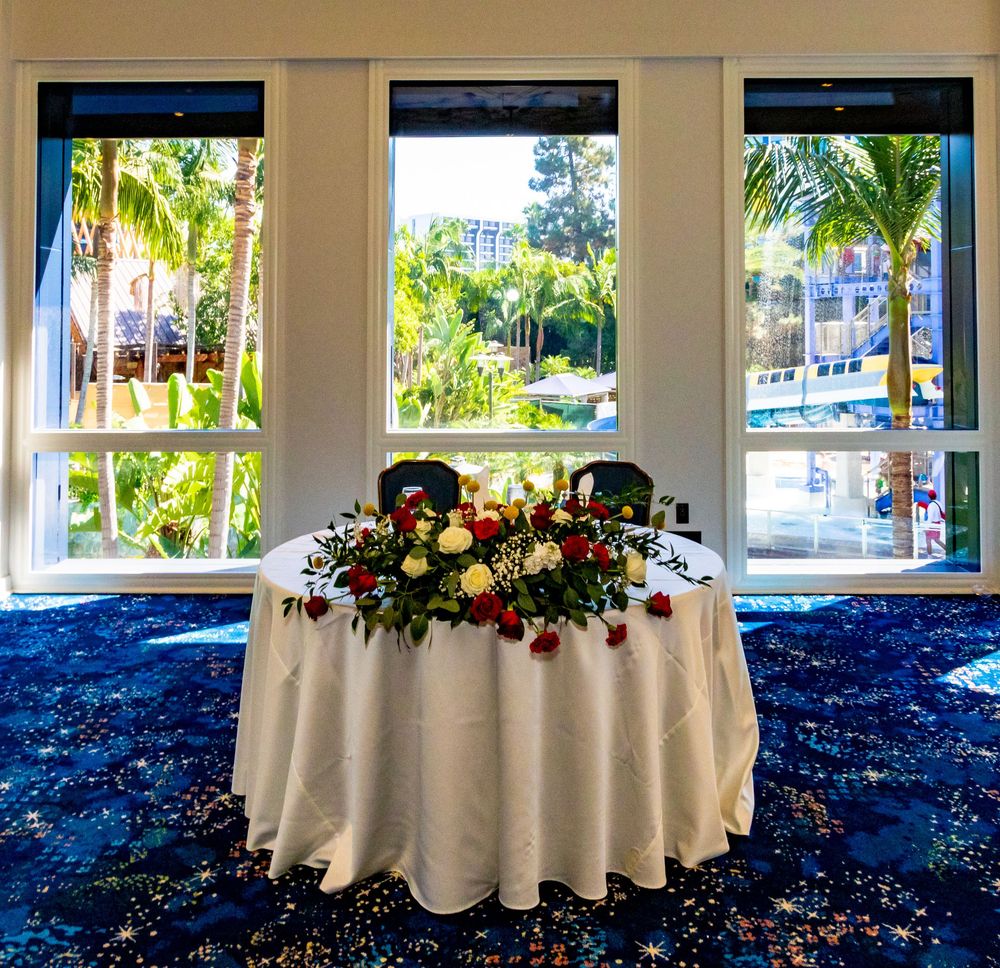 White tablecloth covered round tables with floral centerpieces arranged in an elegant indoor event space.