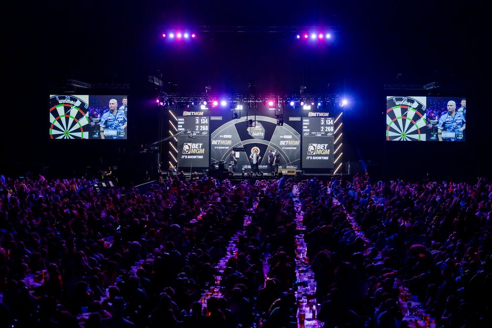 A large stage with a crowd of people in front of it, illuminated by colorful lights.
