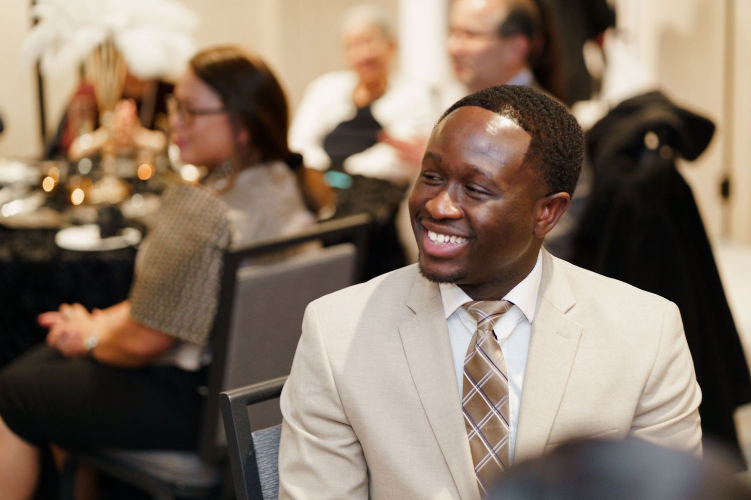 Business professionals engage in animated discussion during a professional networking event.