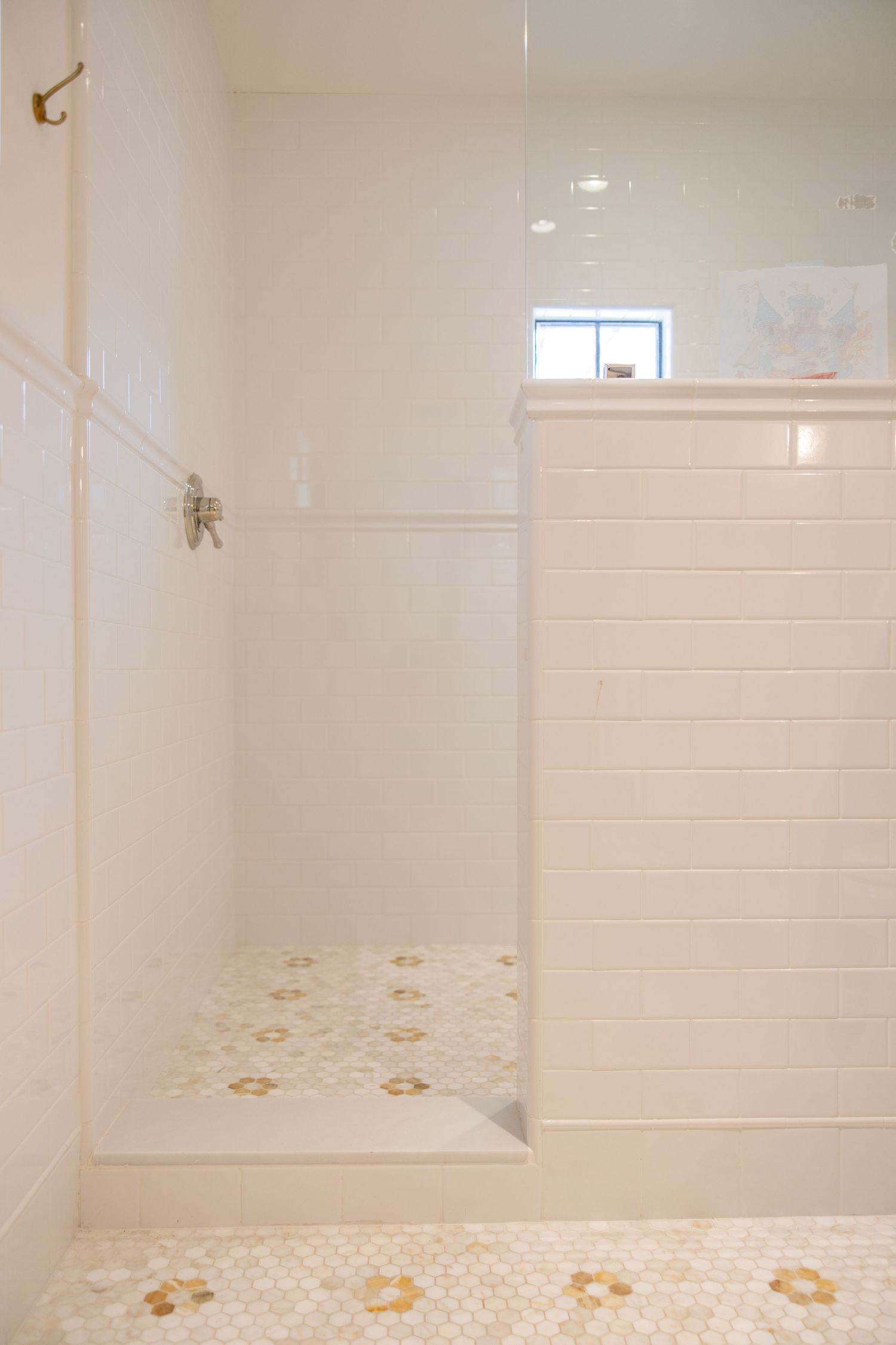 White tiled bathroom with floral pattern floor tiles and a built-in shower enclosure.  Jen Wilbur Photos, Scottsdale Photographer