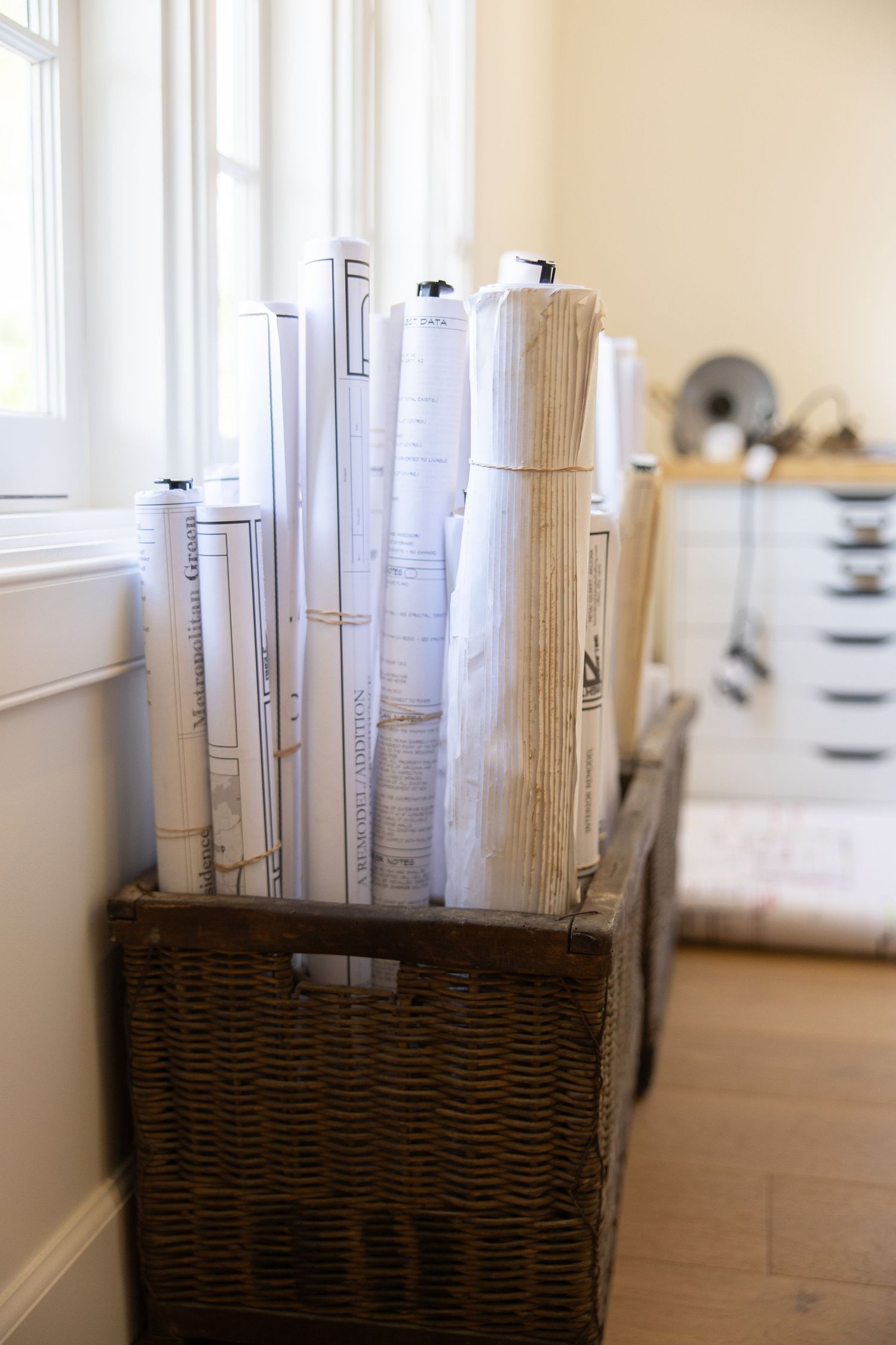 A collection of white curtains and window treatments arranged in a row against a light colored wall. Jen Wilbur Photos, Scottsdale