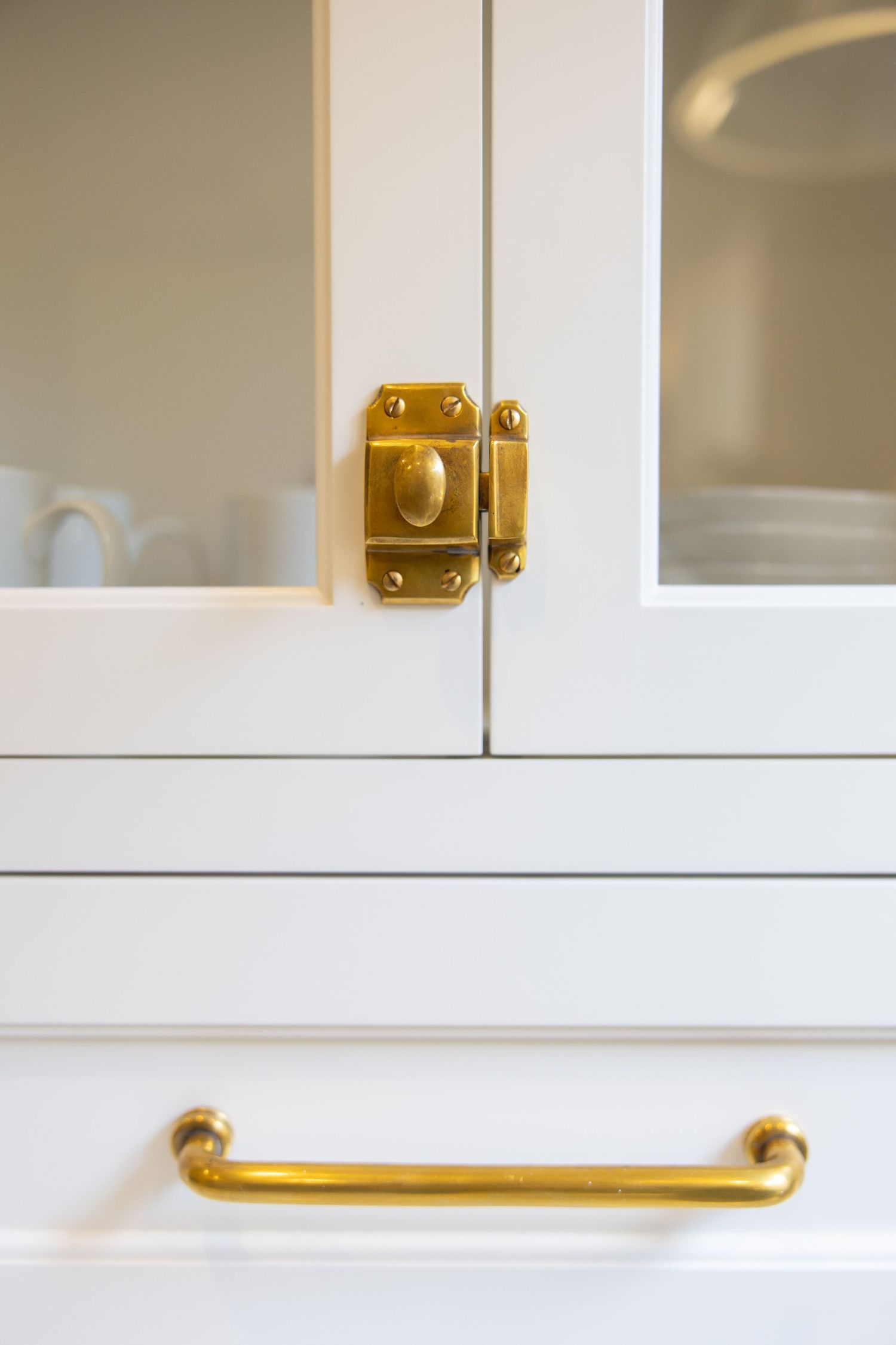 Close-up view of brass cabinet hardware and handles on white kitchen cabinetry. Jen Wilbur Photos, Scottsdale Photographer