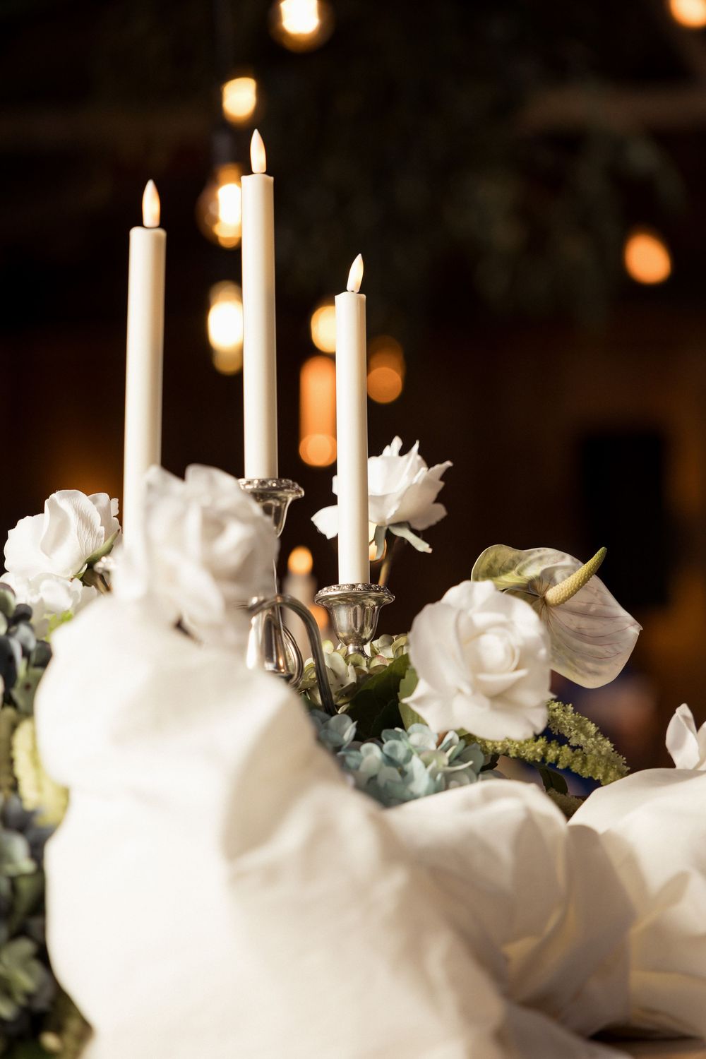 Romantic wedding centerpiece with white candles and roses on dark background  Auckland Wedding Photographer and videographer