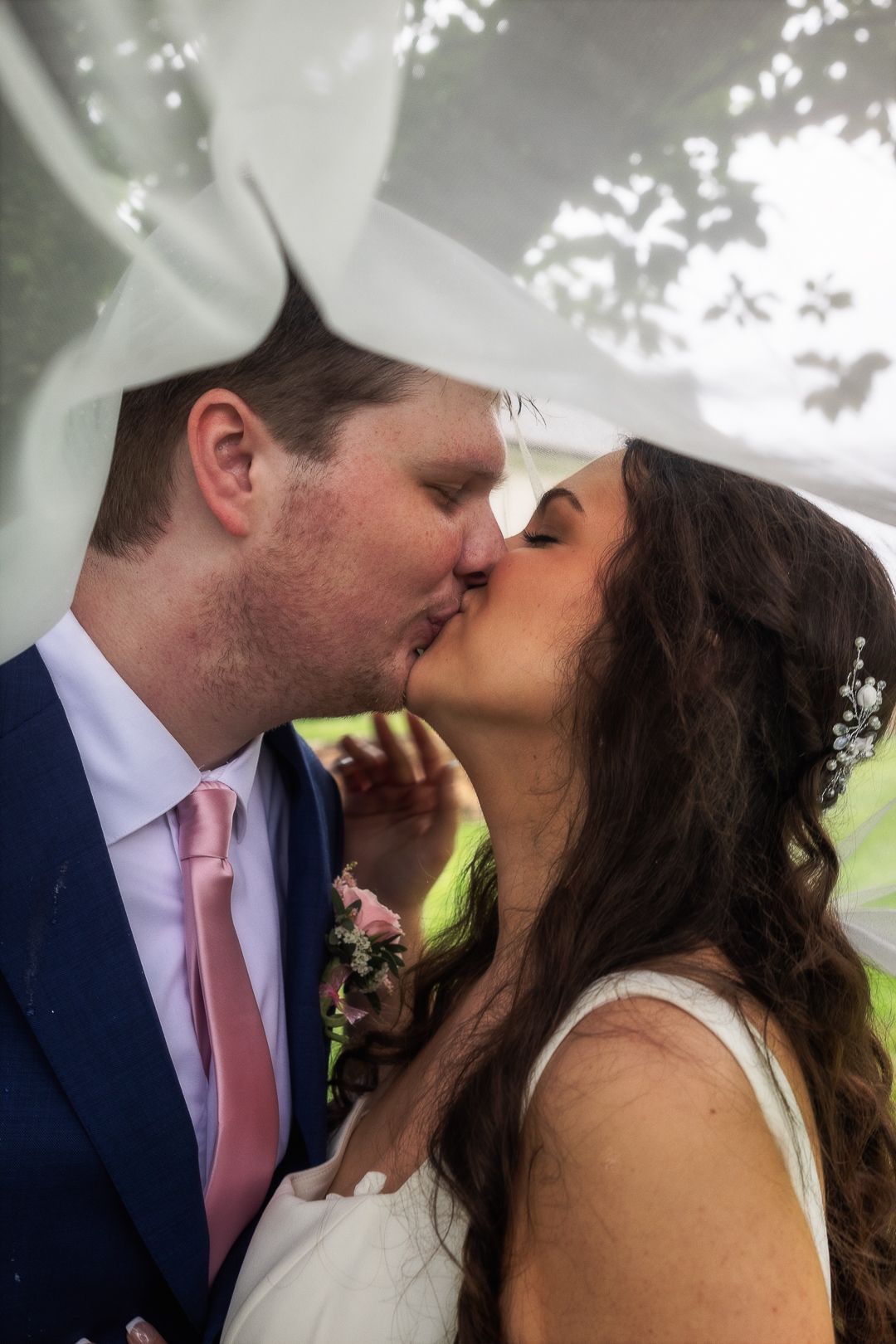 A romantic sequence of wedding photos showing a couple sharing a tender kiss under soft lighting outdoors.