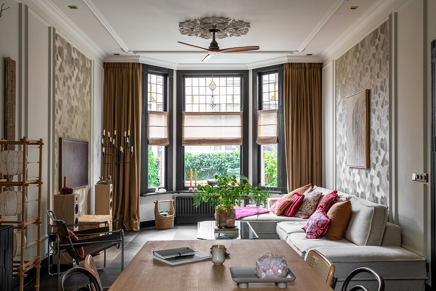 Een interieurfoto van een woonkamer in een oud herenhuis in Den Bosch met oude details en beige en vergrijsde tinten en kleuraccenten.