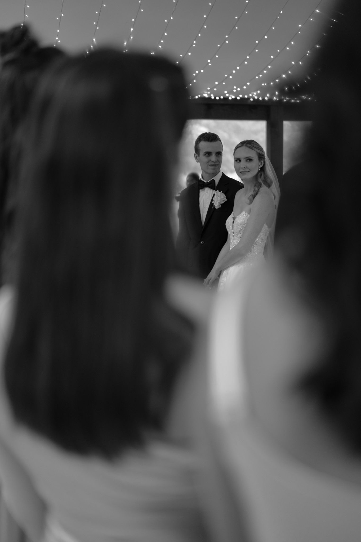 A blurred black and white wedding photo shows a couple standing together in formal attire.