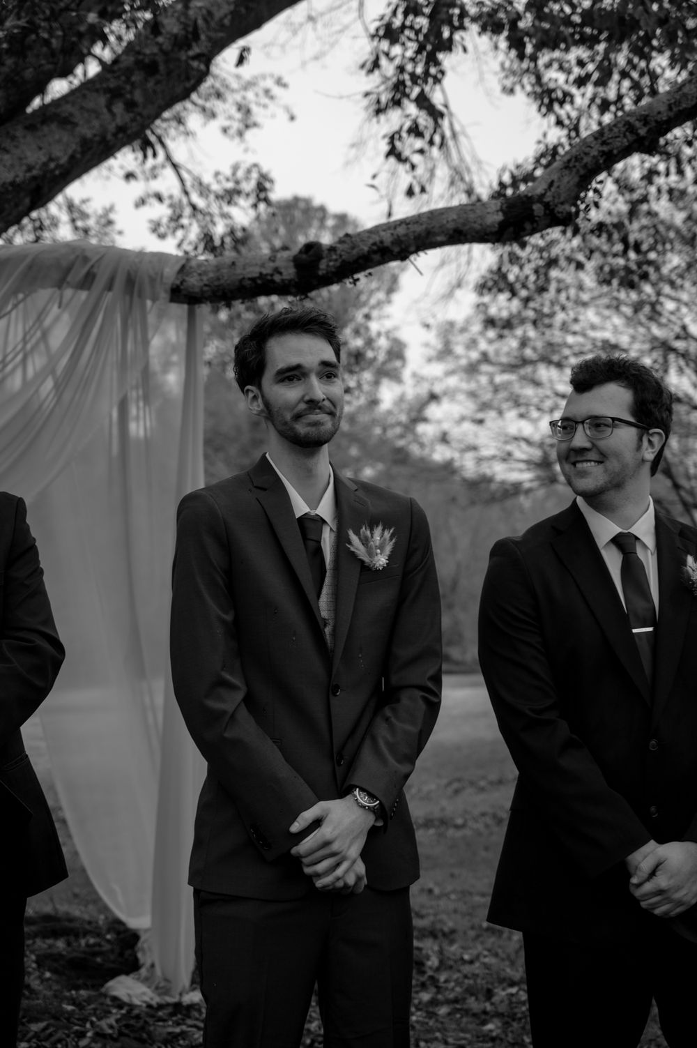 A black and white photo sequence showing emotional reactions during a wedding ceremony outdoors under trees.