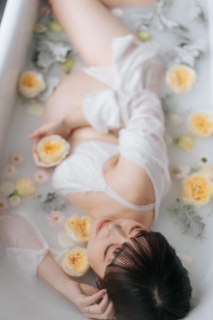 Ethereal milk bath photography with floating yellow roses and white fabric creating a dreamy, romantic atmosphere.空靈的牛奶浴攝影作品，漂浮的黃色玫瑰和白色織物