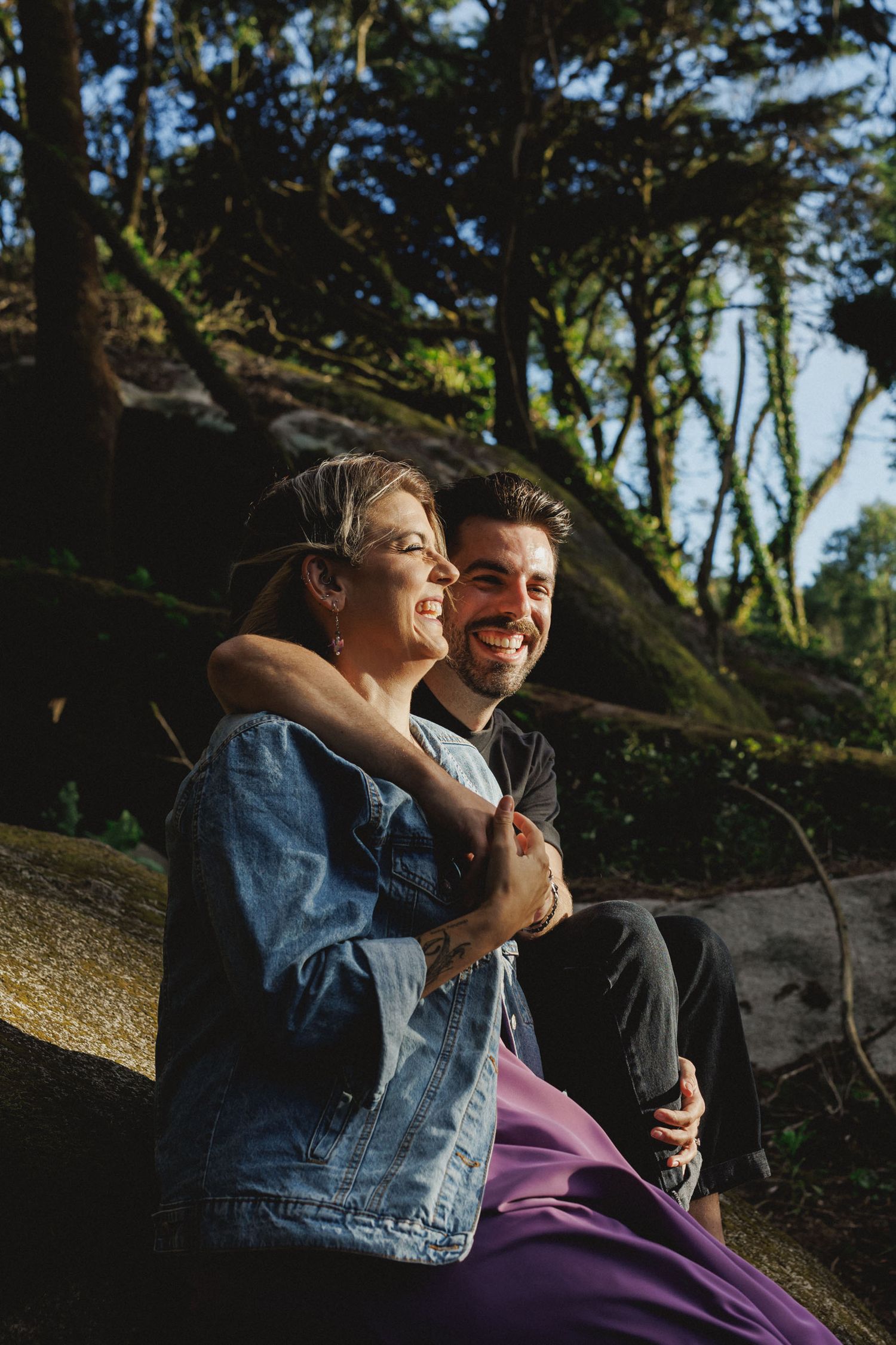 Romantic couple sitting together in forest landscape during engagement session near Peninha, Sintra, Portugal