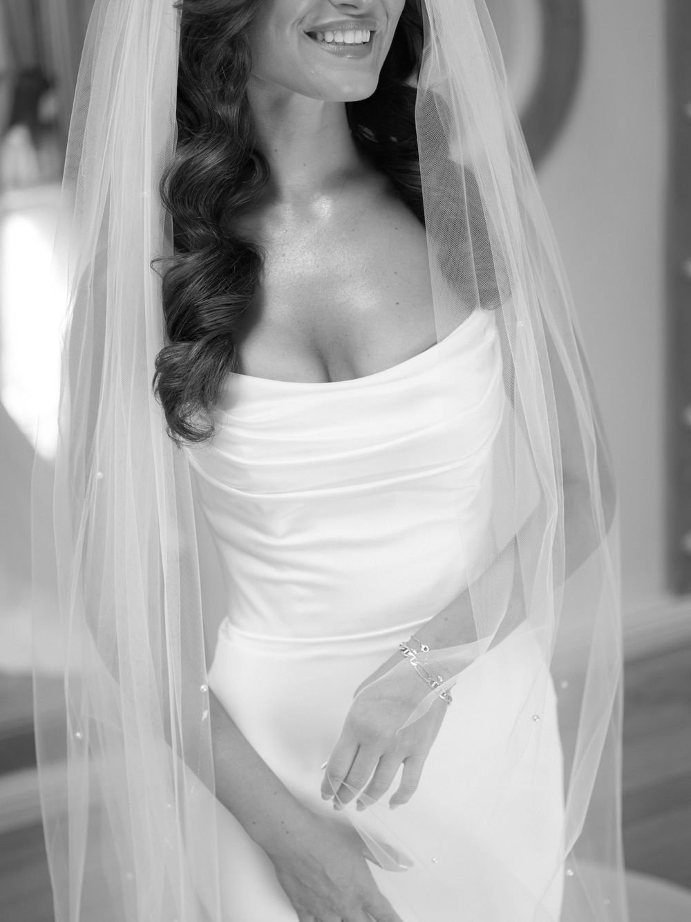 Black and white bridal portraits showing elegant details of a wedding dress and veil.