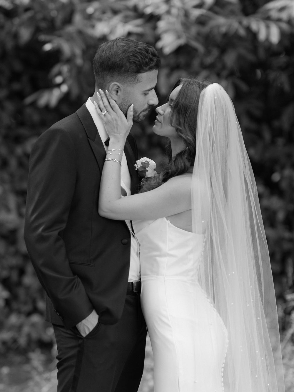 A romantic black and white wedding photo sequence showing tender moments between newlyweds in an outdoor garden setting.