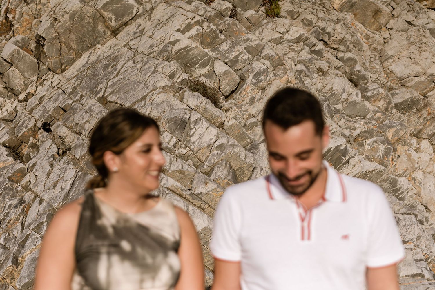 Romantic couple embracing with ocean waves at Praia da Adraga engagement session Sintra