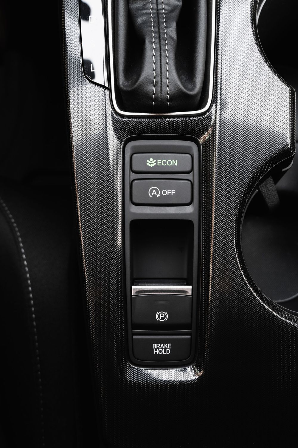 Center console controls showing ECON and brake hold buttons in black interior trim. Mtlshutter photography