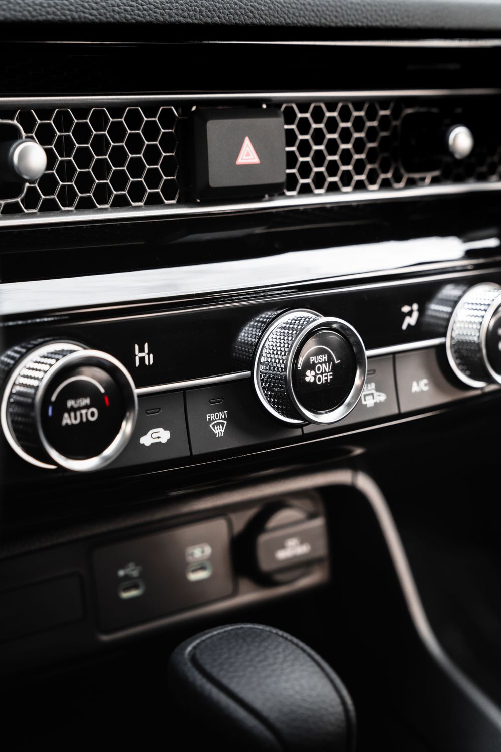 Detailed shot of car climate control panel with honeycomb pattern grille. Mtlshutter photography