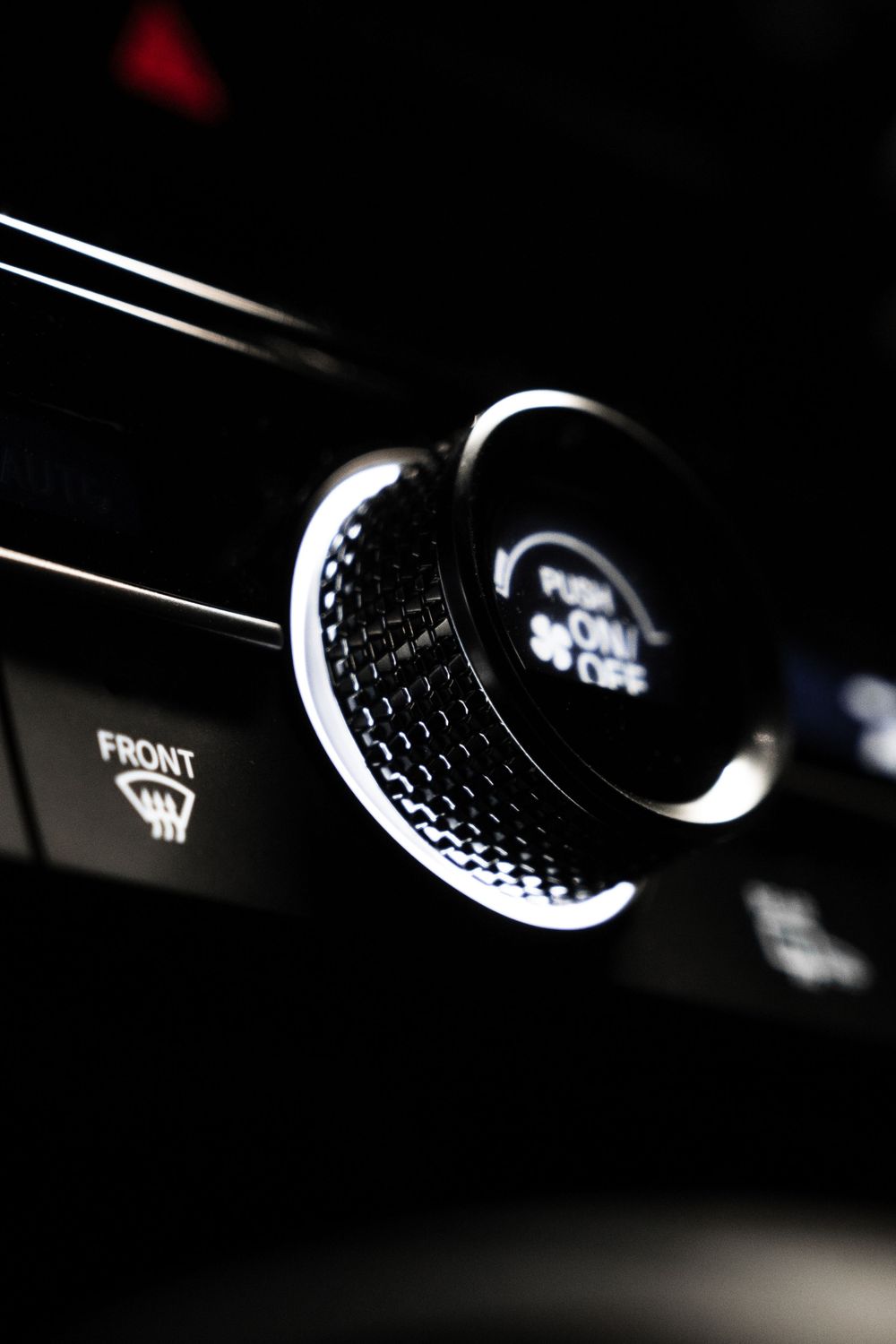 Close-up of illuminated climate control dial in dark vehicle interior. Mtlshutter photography