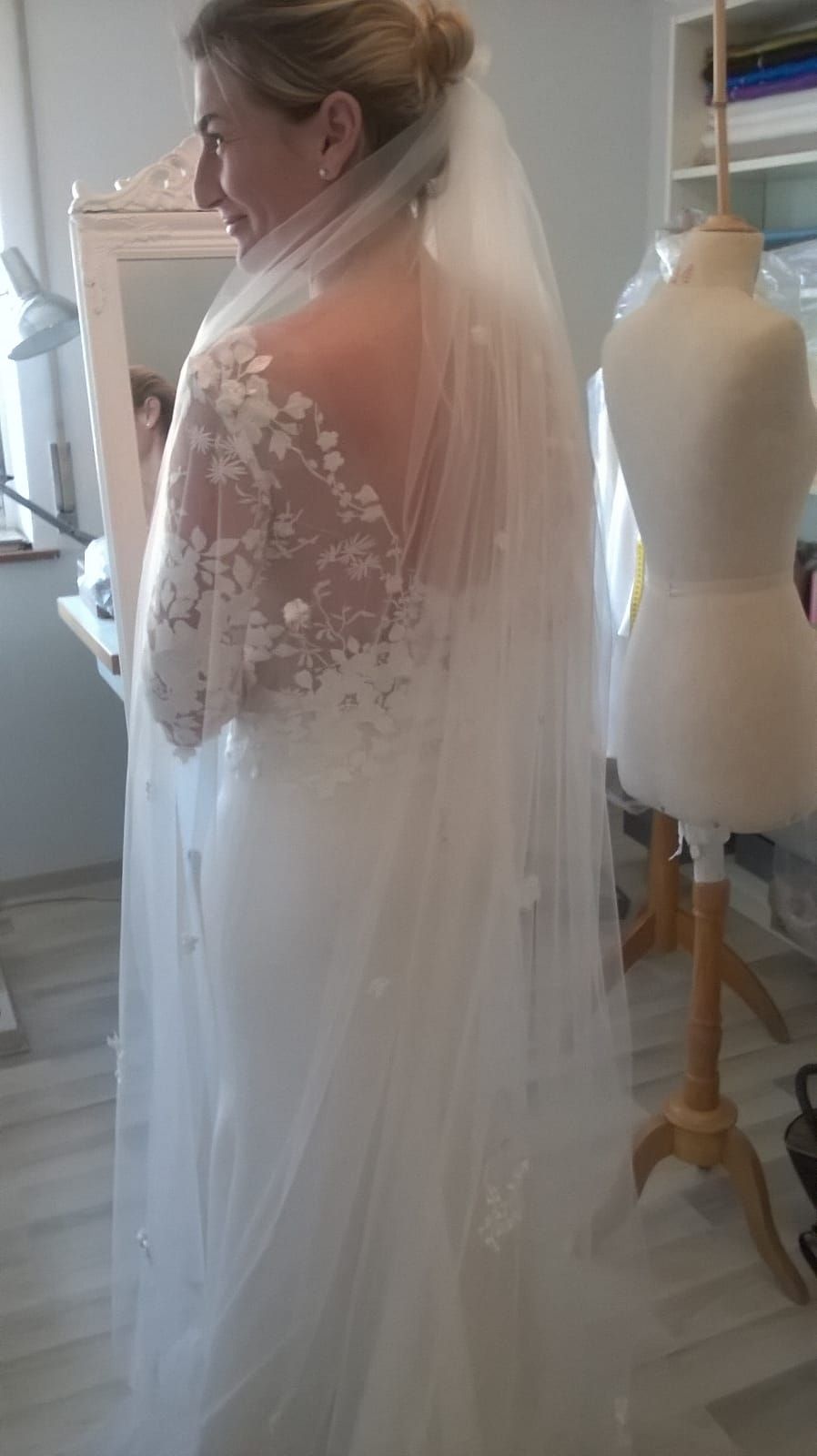 Frau in einem Atelier probiert ein Brautkleid an