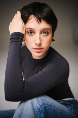 Expressive studio portrait featuring minimalist black and denim outfit.
