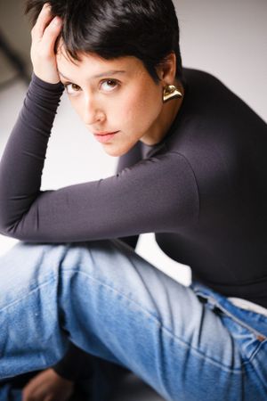 Artistic fashion portrait with dramatic lighting and casual styling.