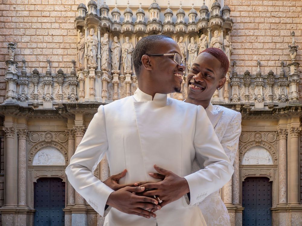 A couple gazes affectionately at each other while posing in the cloister of Montserrat.