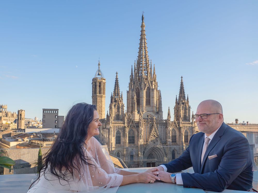 A couple celebrating their wedding with the Gothic Barcelona cathedral in the background.