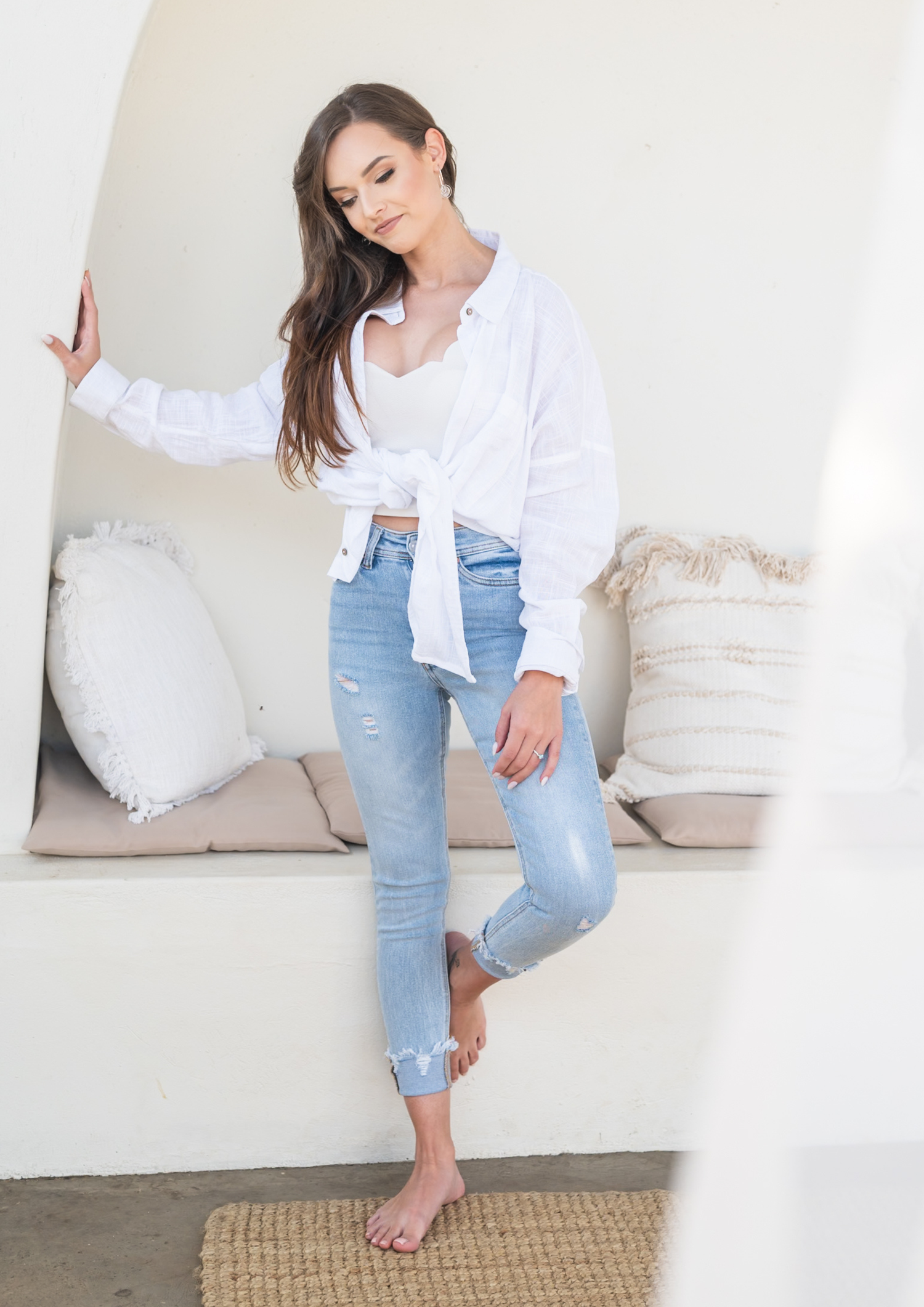 Casual lifestyle photo series showing relaxed poses in distressed jeans and white shirt on light neutral background.